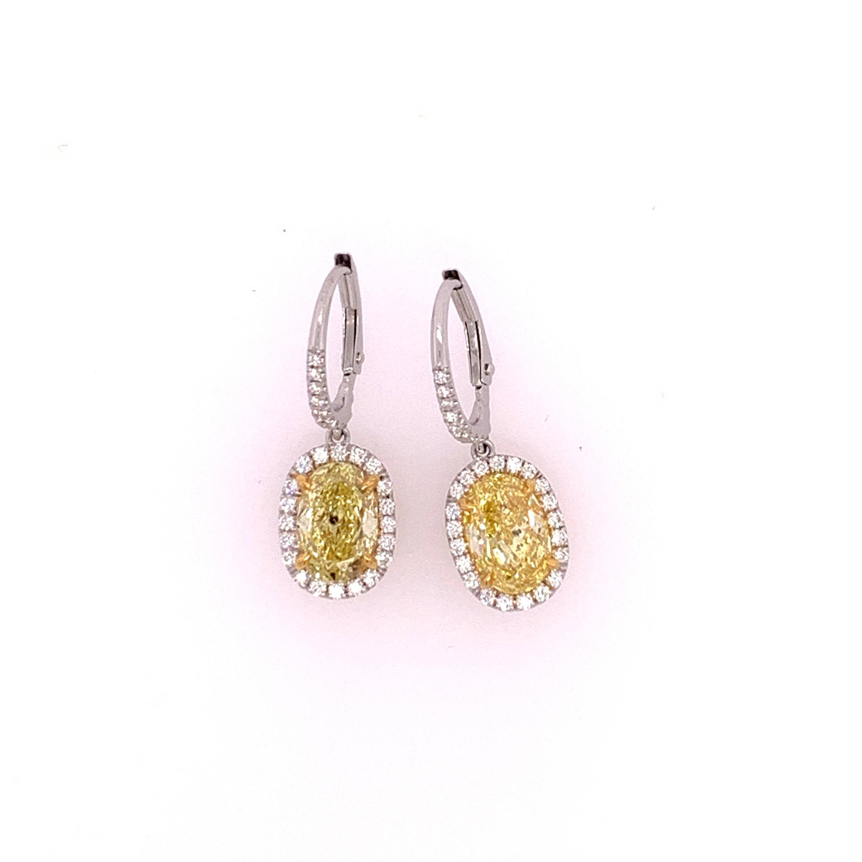 Platinum diamond earrings set with 0.42cts of colorless round brilliant diamonds. The yellow ovals are natural strong canary color. The cut on these Ovals are ideal proportions making it look larger than its weight, each stone has the measurements