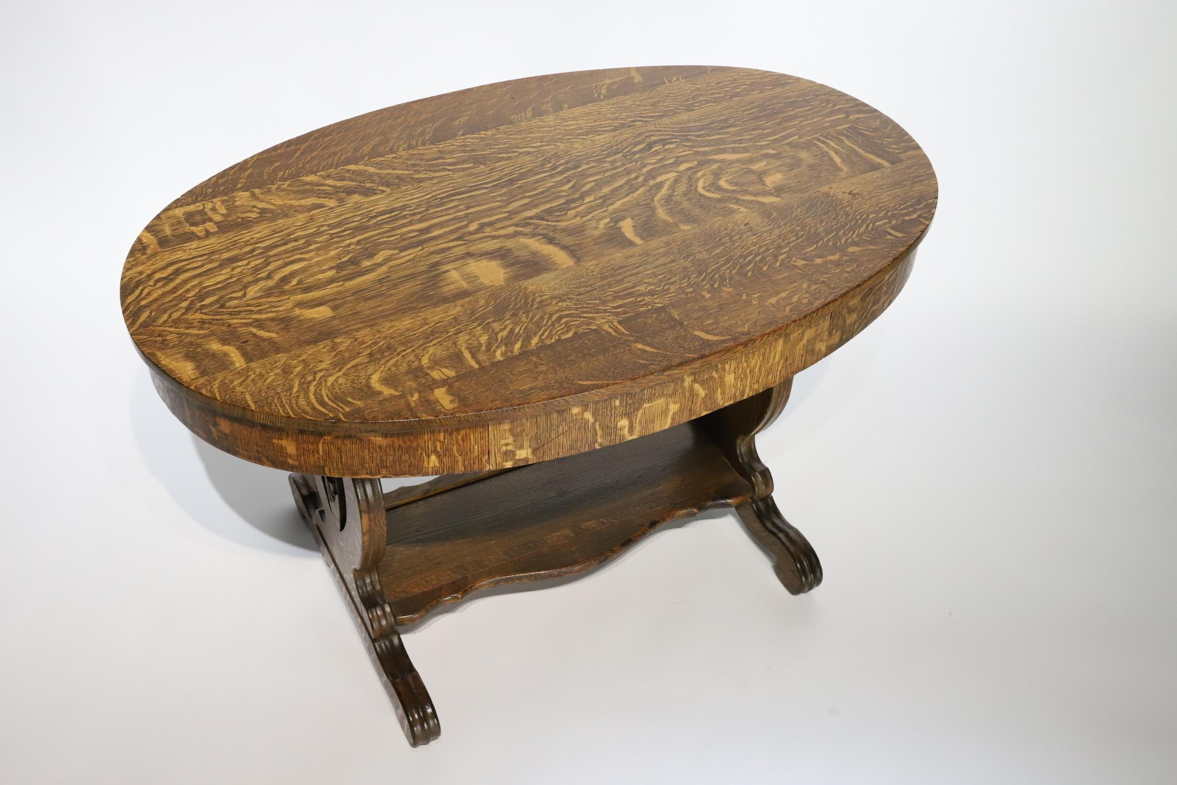 Stunning oval quarter sawn oak library table with sleek hidden drawer. Would make for a wonderful entry table or small writing desk.
