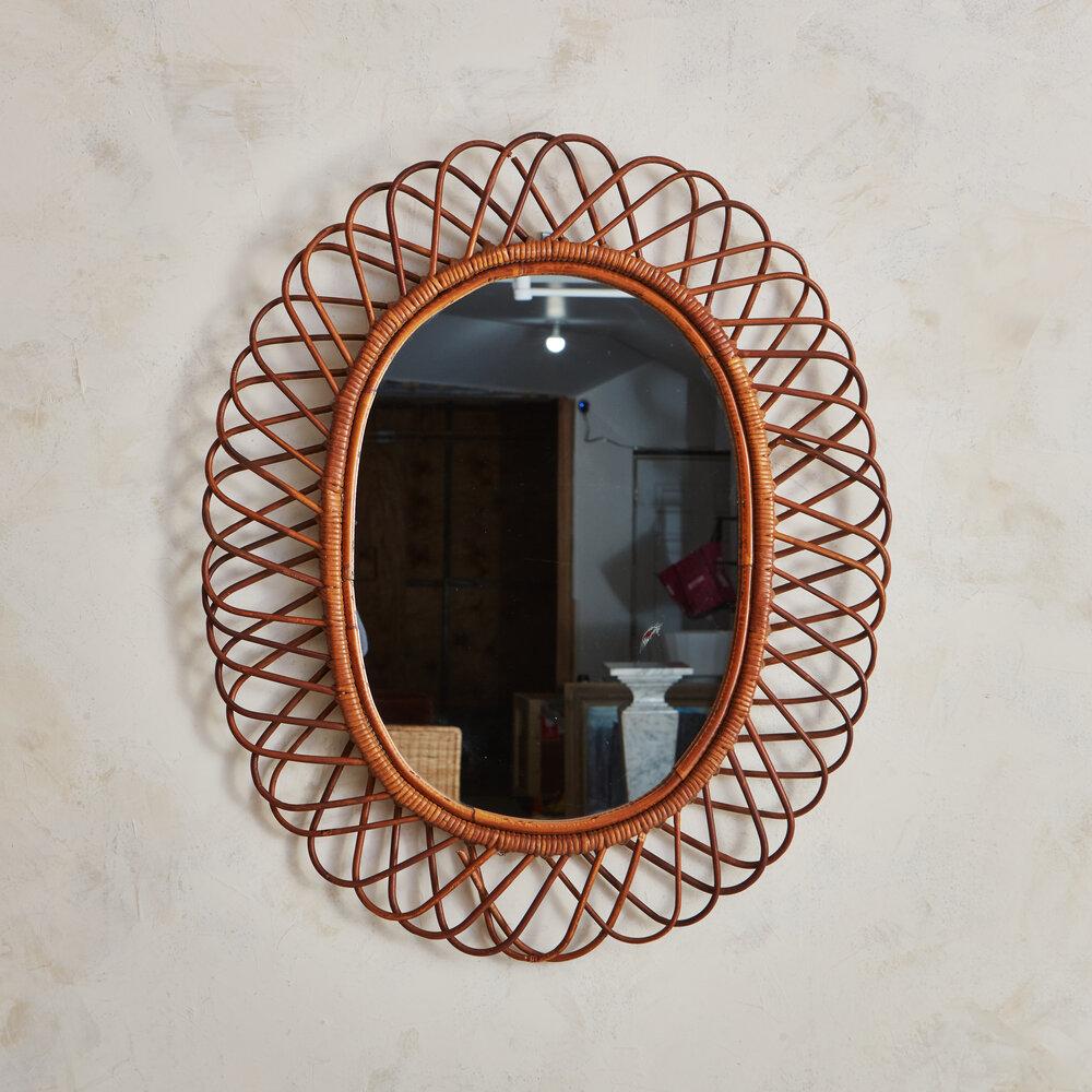 A French Riviera style starburst rattan and bamboo mirror. Similar to works by Franco Albini and produced by Bonacina in the 1950s and 60s. Sourced in France.