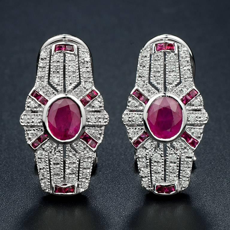 Pair of Art Deco design with ruby and diamond earrings, each of shield-shaped, millegrain set with round diamonds and French cut ruby surround the natural oval ruby. 14K White Gold. 
Information
Width: 12 mm.
Length: 22 mm.
Weight: 7.71 g. (approx.