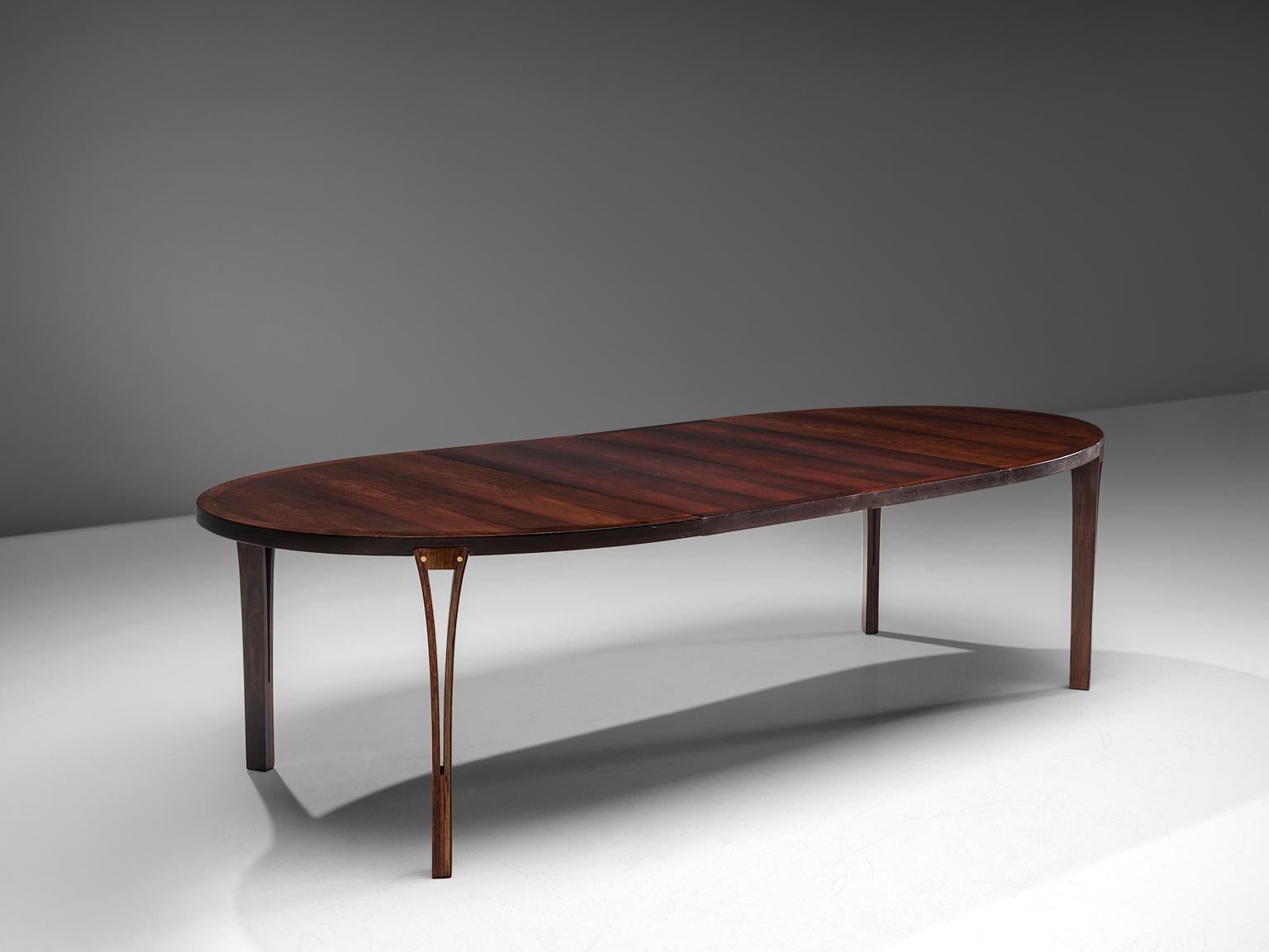 Dining table, rosewood, brass, Denmark, 1960s.

This exceptional dining table with extension leaves features four tapered circular legs beautifully spared into the plinth. The top shows an expressive rosewood grain, which gives it a warm look. The