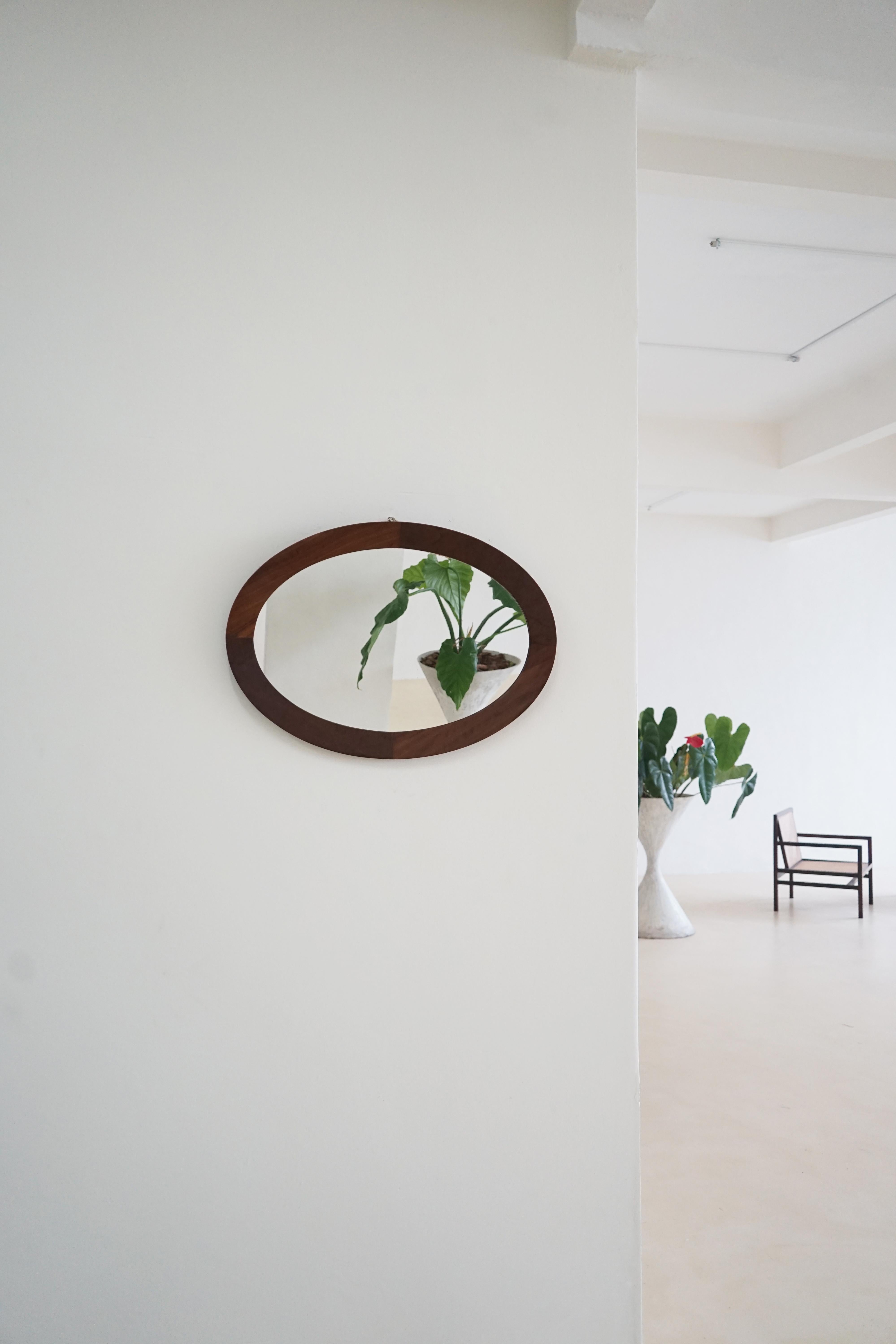 Miroir ovale avec cadre en Imbuia massif produit dans les années 1960 par la société brésilienne Celina Decorações.

La société Celina Decorações a signé l'une des lignes les plus modernes de meubles brésiliens dans les années 1960. Basée à Rio de