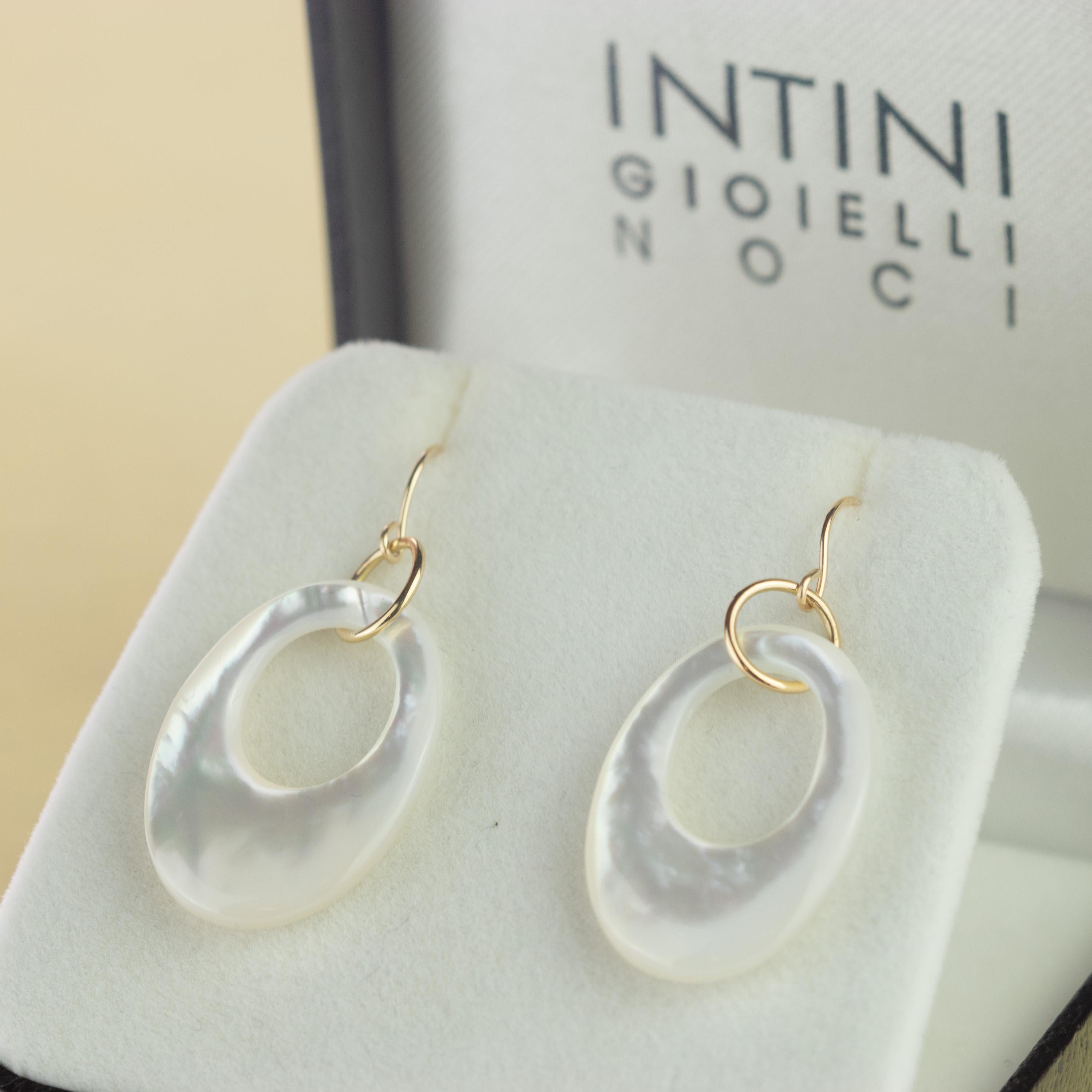 Boucles d'oreilles pendantes en nacre naturelle ovale et élégante avec un trou circulaire à l'intérieur. En forme de beignet tenu par  or jaune 18 carats. Pièce contemporaine et unique conçue avec un style moderne et jeune. 
  
Ces bijoux sont