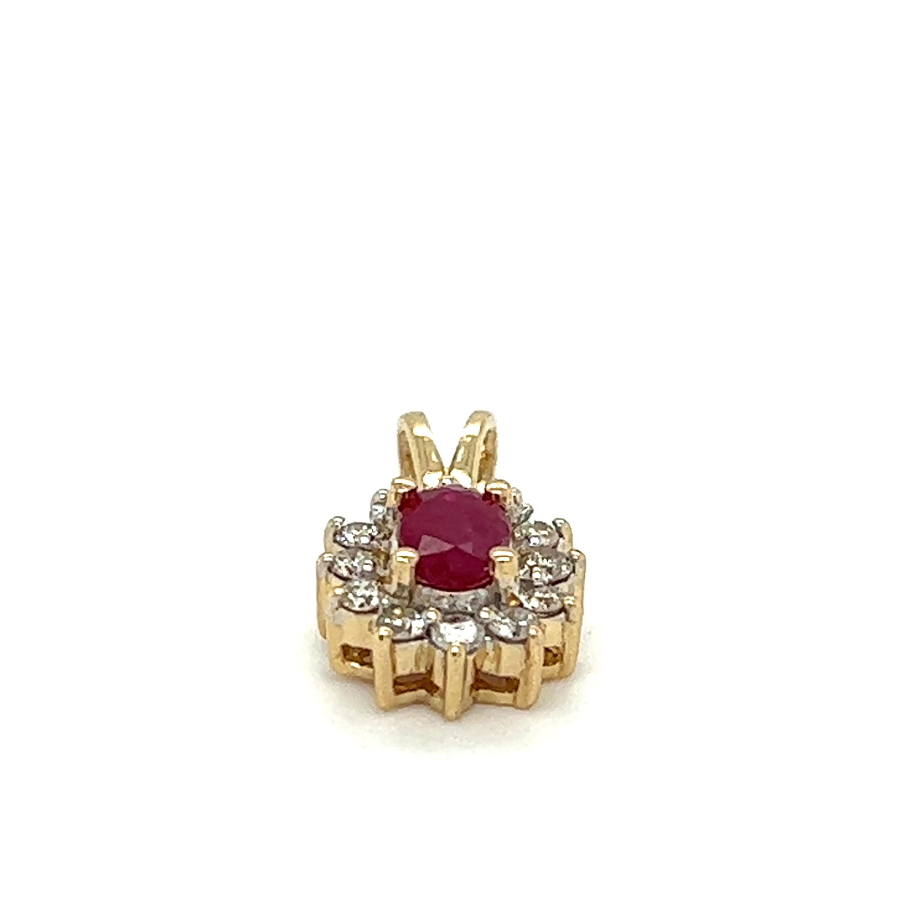 One 14 karat yellow gold cluster pendant set with one (1) 6x4mm oval natural ruby, surrounded by twelve (12) round brilliant cut diamonds, approximately .18 carat total weight with matching K/L color and SI1 clarity. The pendant measures 17.00mm