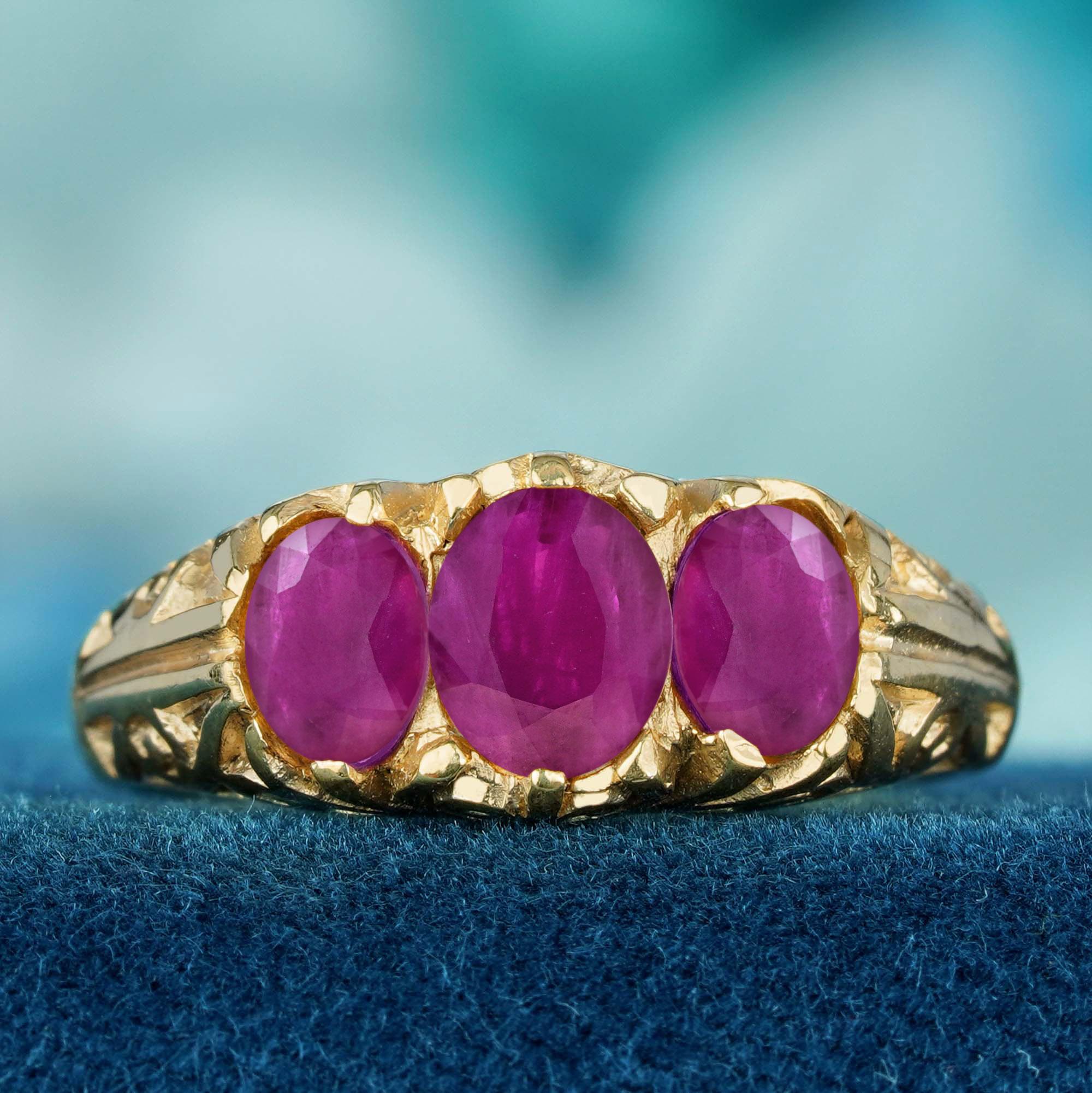  Al centro c'è un vibrante rubino di forma ovale, completato da due pietre scintillanti ai lati. L'elegante montatura di ispirazione vintage mette in risalto il ricco colore del rubino, mentre gli intricati dettagli della fascia aggiungono un