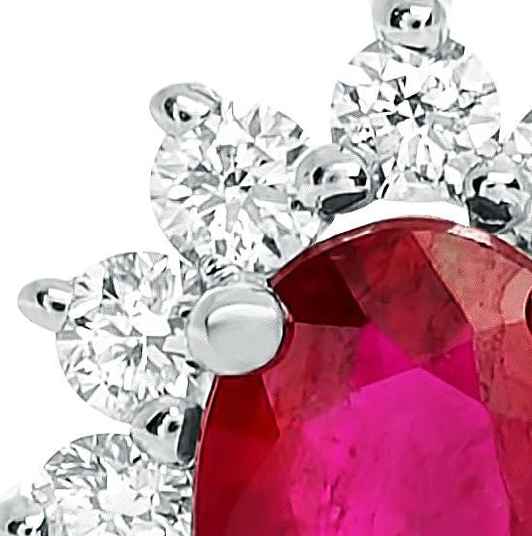 Réalisé en or blanc 18 carats, ce pendentif met en valeur un rubis rouge lumineux de 0,50 carat, de taille ovale, en son centre. La pierre centrale colorée est animée par 0,20 carats de diamants blancs de taille ronde dans un halo unique