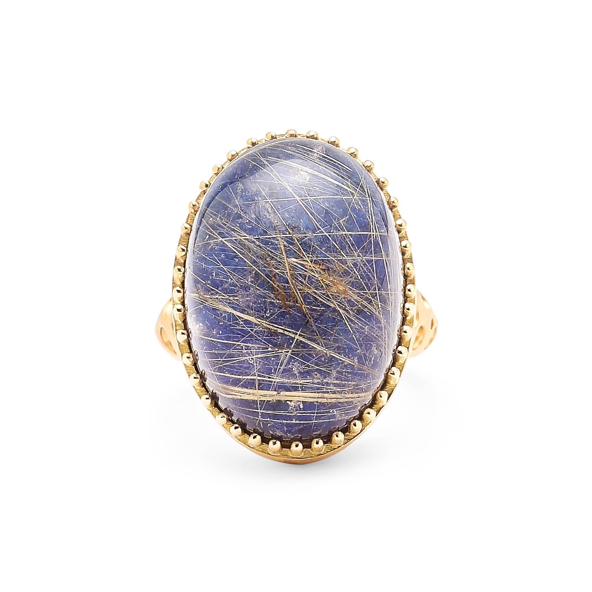 Oval Rutilated Quartz over Lapis Lazuli Doublet Ring with Oculus Band.

This extremely unique gemstone creates an extremely unique, quietly bold and beautiful cocktail ring, that can be worn any time of day or night. Many 18 karat yellow gold prongs