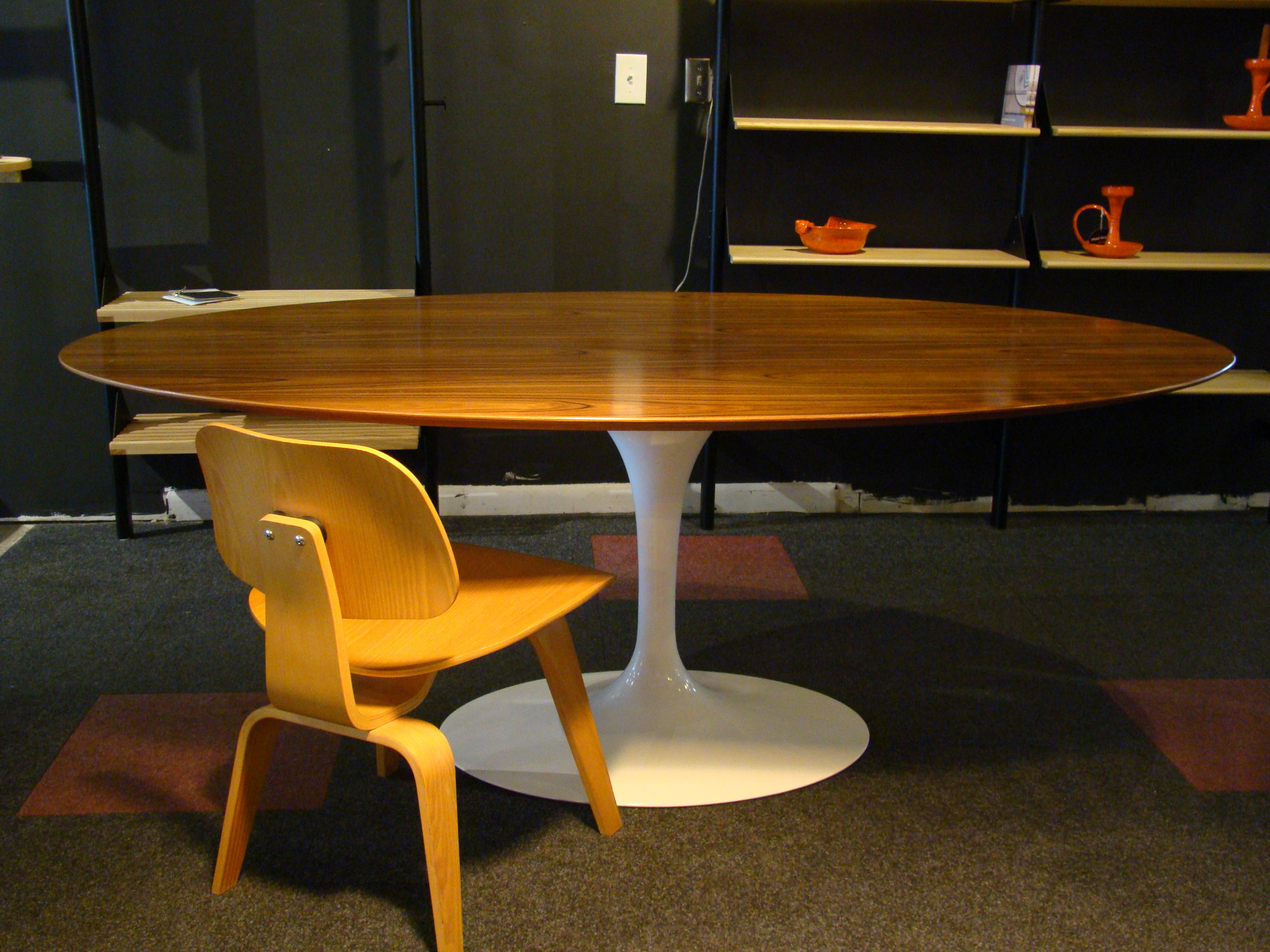 Highly desirable teak top oval Saarinen tulip table manufactured by Knoll International. This example is manufactured post Y2K with a 