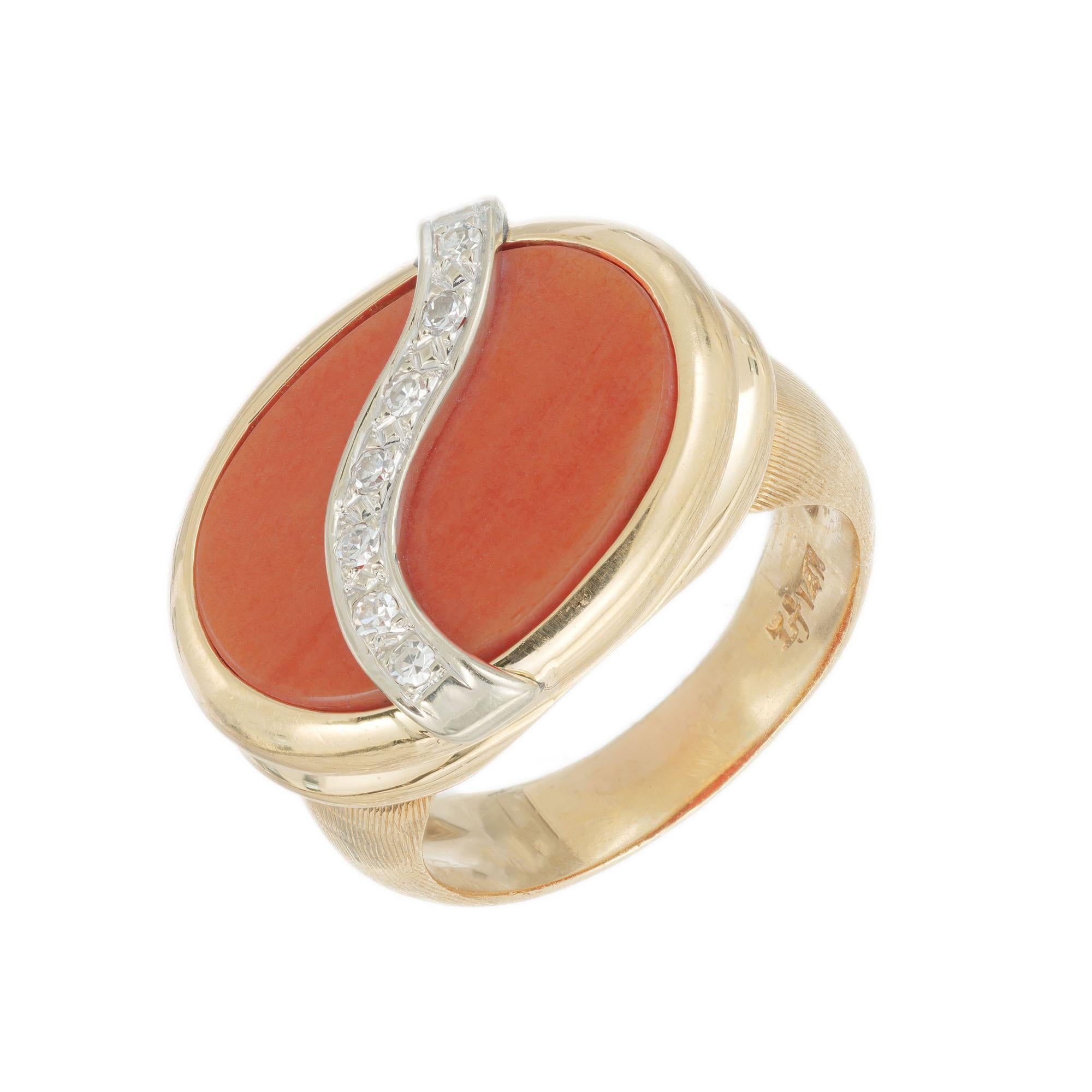 Mid-Century 1960's Salmon coral and diamond cocktail ring. Genuine untreated Salmon oval coral set in 14k yellow gold with a 14k white gold swirl accented with 7 single cut diamonds. 

1 Genuine untreated oval Salmon color coral 17.5 x 12.5mm
7
