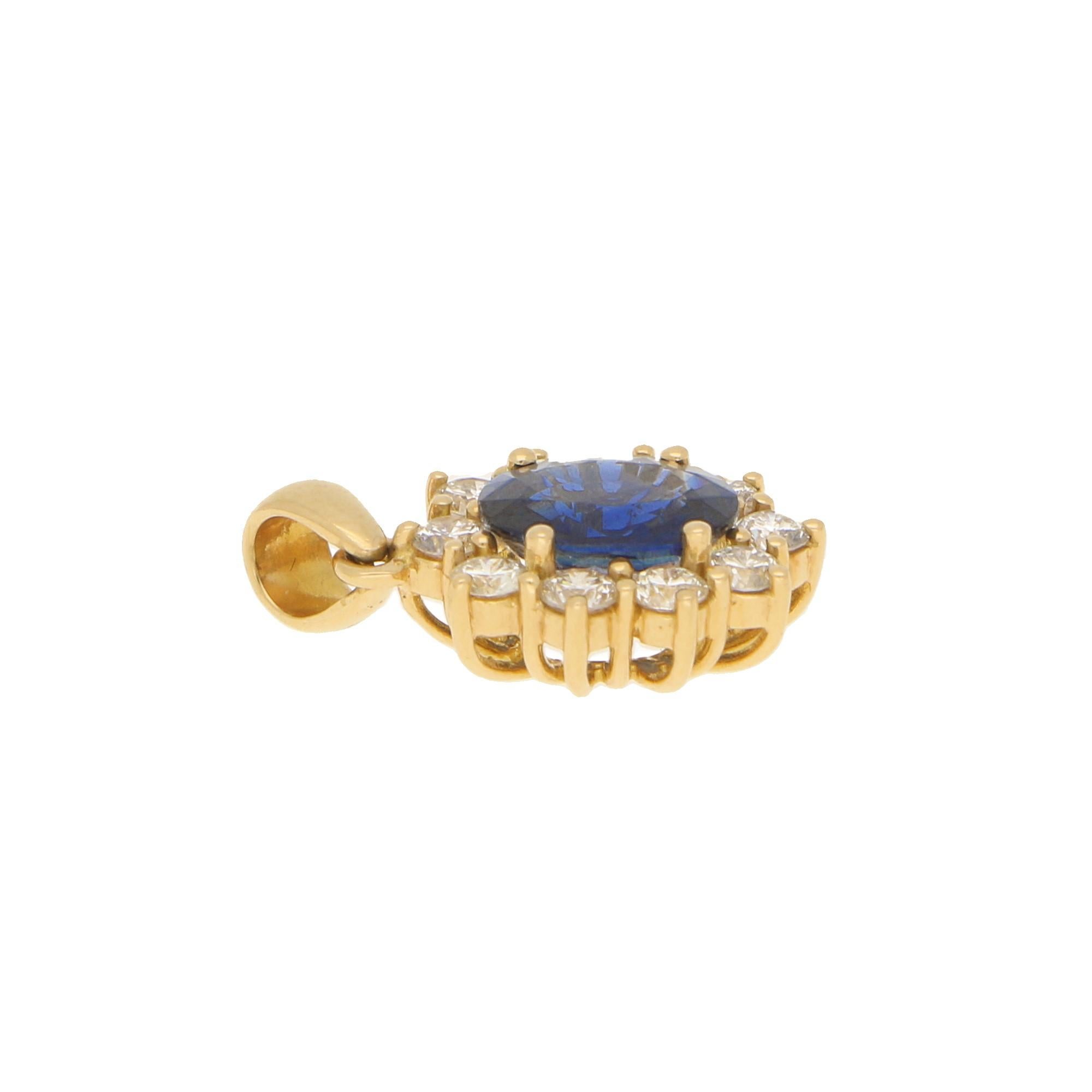 An elegant sapphire and diamond cluster pendant set in 18k yellow gold. 

The pendant centrally features and large royal blue coloured oval sapphire which is four claw set to centre. This oval sapphire is then surrounded by a halo of 10 round