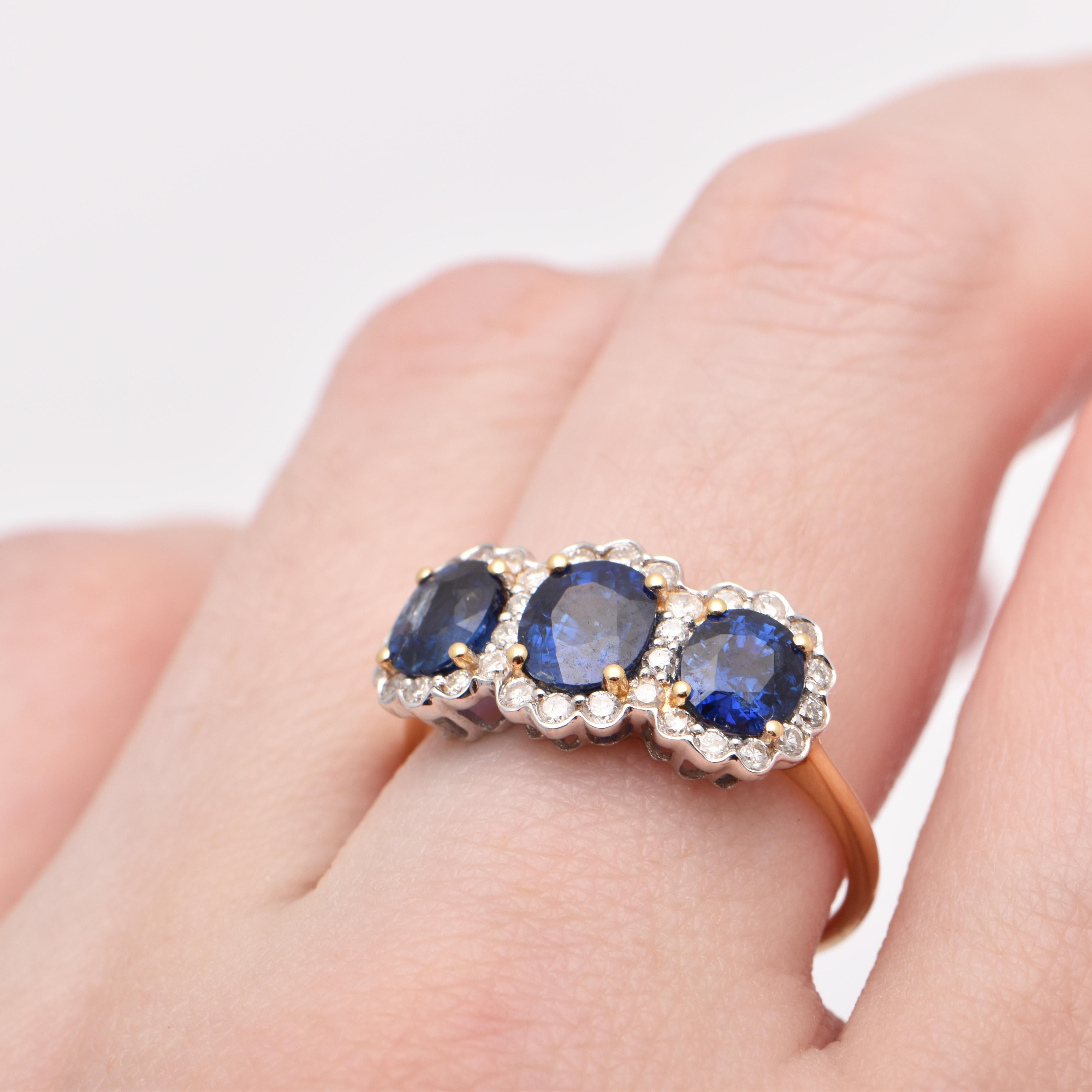 Oval Sapphire and Diamond Halo Trilogy Ring in 18 Carat Yellow Gold For Sale 1