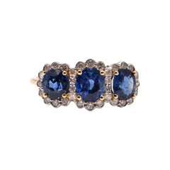 Oval Sapphire and Diamond Halo Trilogy Ring in 18 Carat Yellow Gold