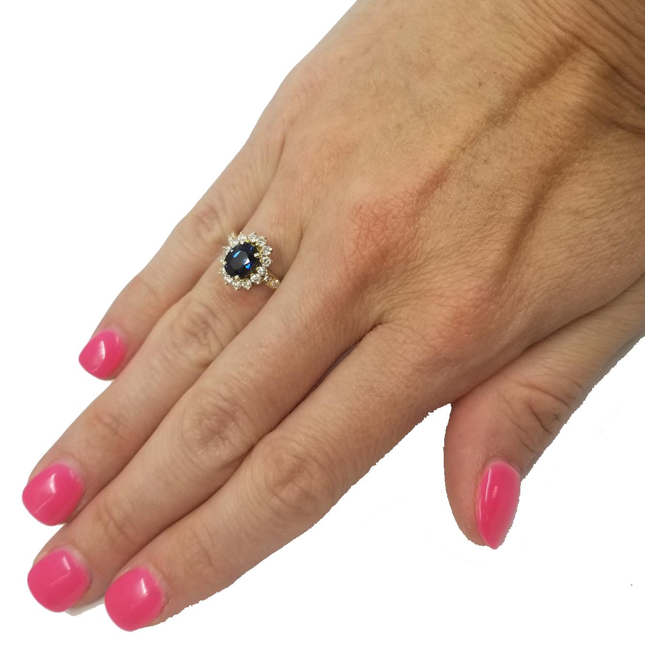 14 Karat Yellow Gold Ring Featuring An Oval Sapphire Approximately 1.00 Carat and 24 Round Diamonds Totaling Approximately 0.50 Carat of VS Clarity & G Color. Professionally polished to remove scratches. Finger Size 5.75; Purchase Includes Sizing