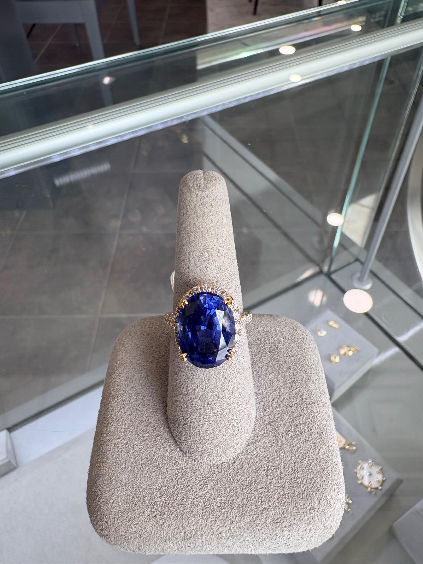 Questo squisito anello aureola da donna è realizzato in lussuoso oro giallo 18 carati, progettato per irradiare eleganza e brillantezza senza tempo. Al centro si trova uno zaffiro ovale composto da 12,75 carati, che mostra una ricca tonalità di blu