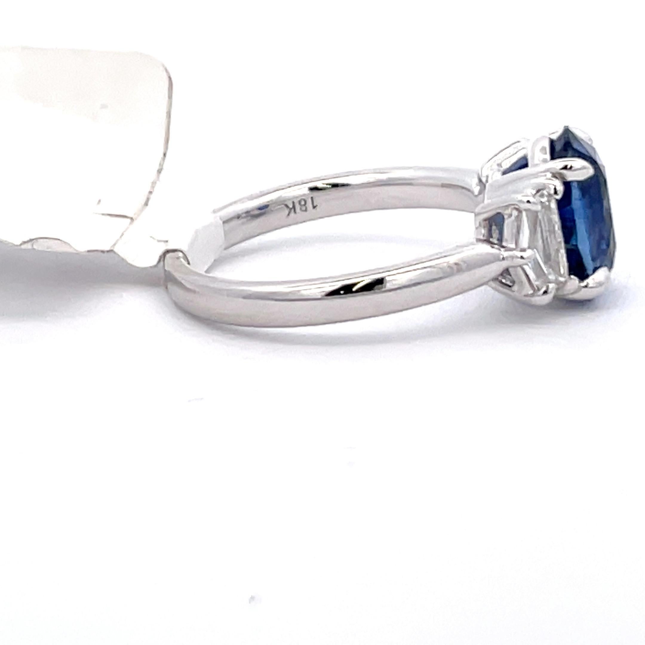 Three stone ring featuring one Oval cut blue Sapphire weighing 2.99 Carats flanked with two ? weighing 0.54 carats, in 18 Karat White Gold. 
Ring measures 13.9 MM Wide

Call/Message us to discuss more in detail.

DM for more Info & Videos on my