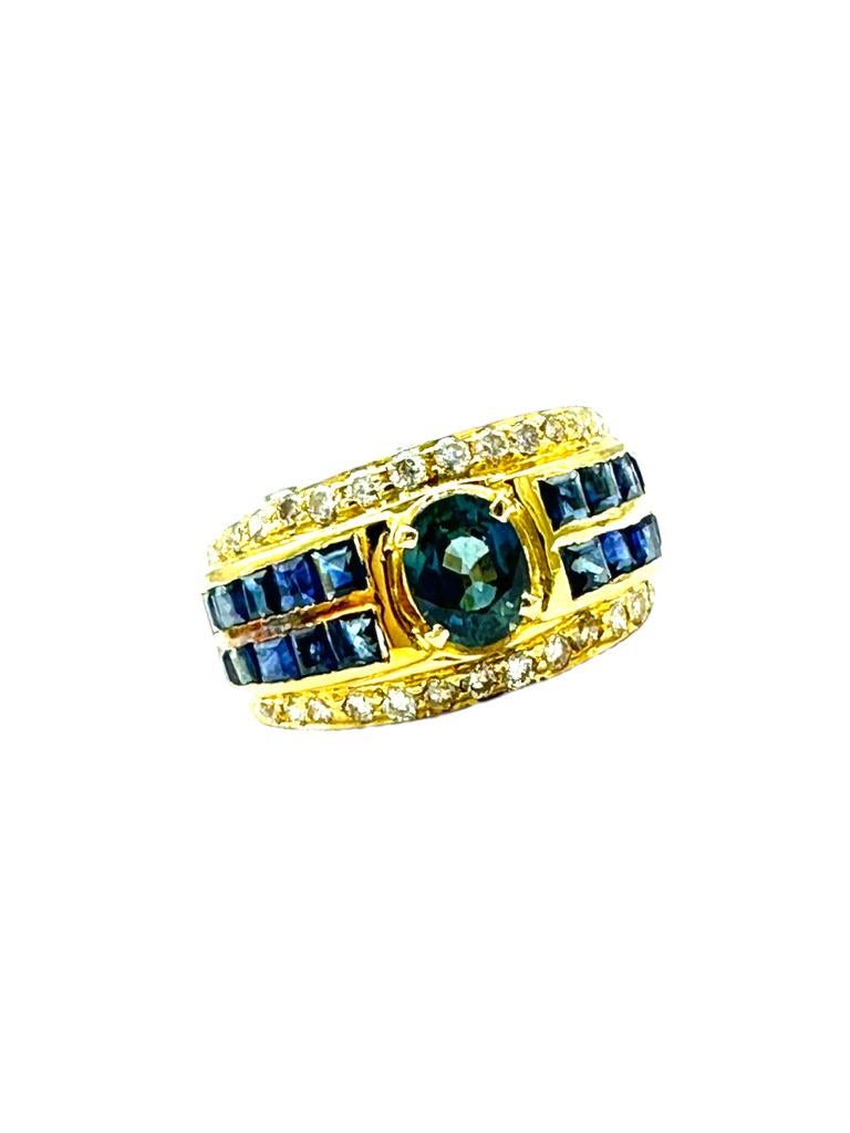 This ring is a wide band measuring 11 millimeters and is set in a rich 18-karat yellow gold metal.
The center Oval sapphire measures 6.20-5.02 x 2.55 weighing an estimated .75 carat. 
The color is blue and consistent with quality gemstone. 

The