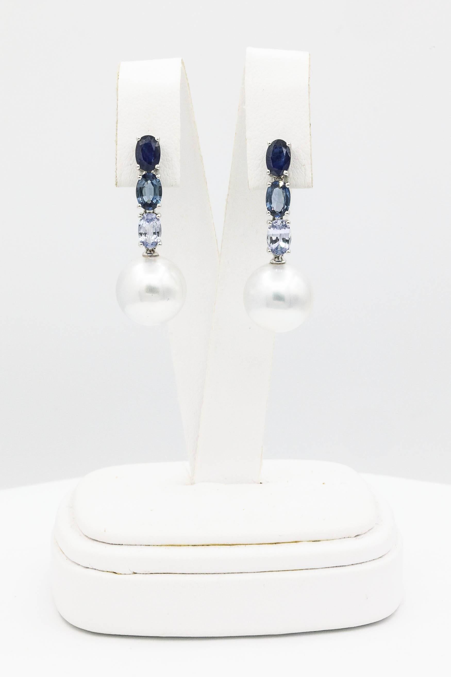 18K White gold drop earrings featuring 6 oval Sapphires weighing 3.00 carats and two South Sea Pearls measuring 11-12 mm.