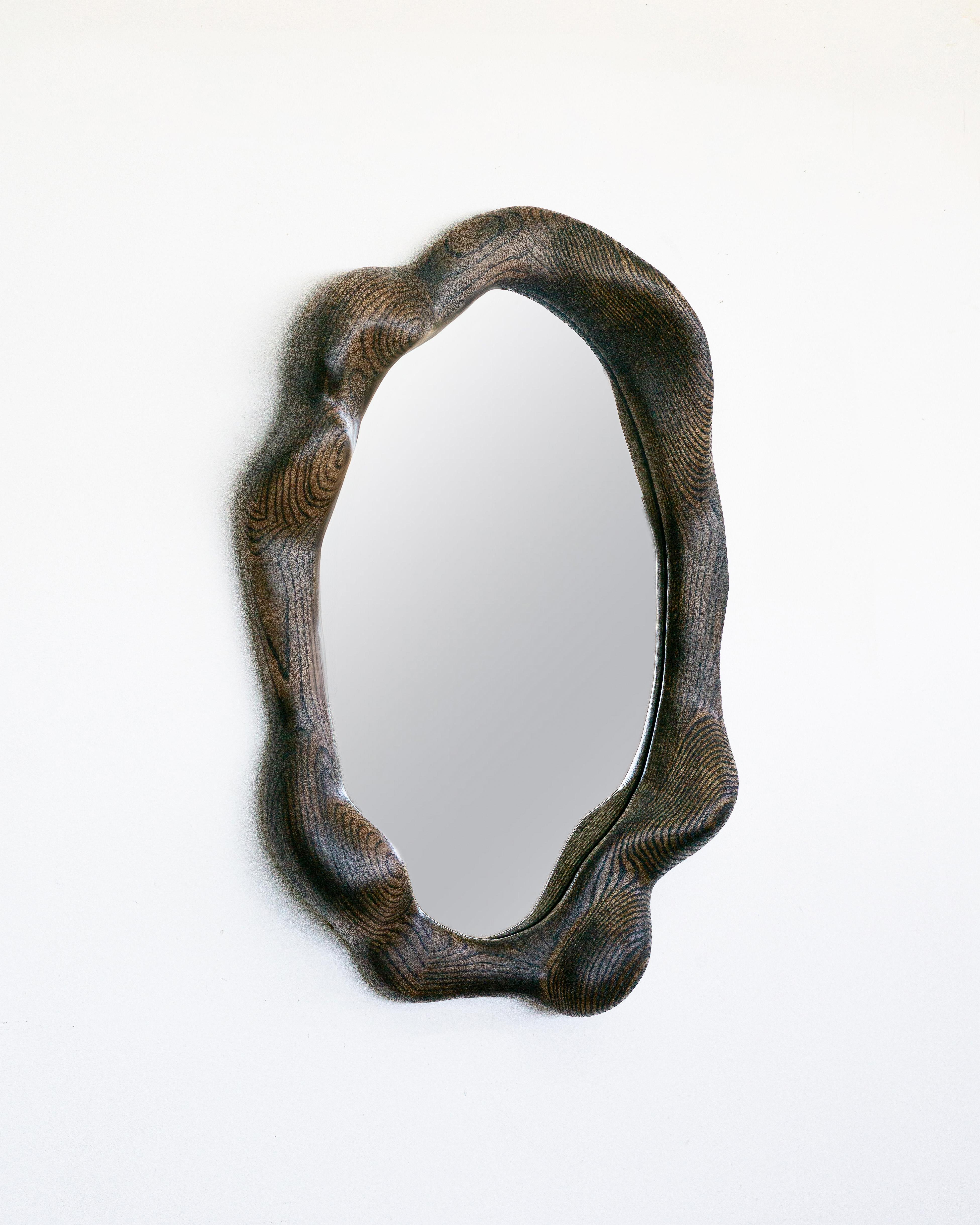 The frame of the mirror is shaped using various hand tools, making each piece unique with its own distinctive wood grain. The mirror is made from high-quality red oak, which is lightly burned and finished with a hardwax oil.

The mirror is mounted