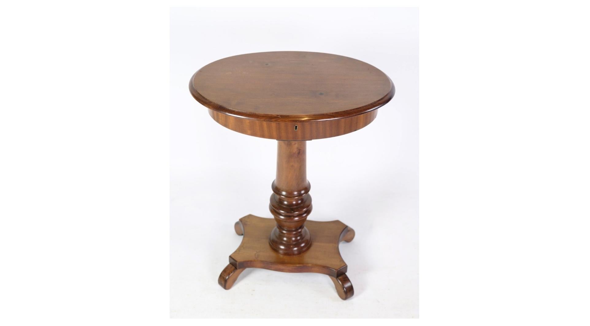 An exquisite oval sewing table/lamp table on a pillar with a mahogany sewing room, originating from the 1890s. This remarkable piece embodies the elegance and craftsmanship of the late 19th century, offering both functionality and beauty to any