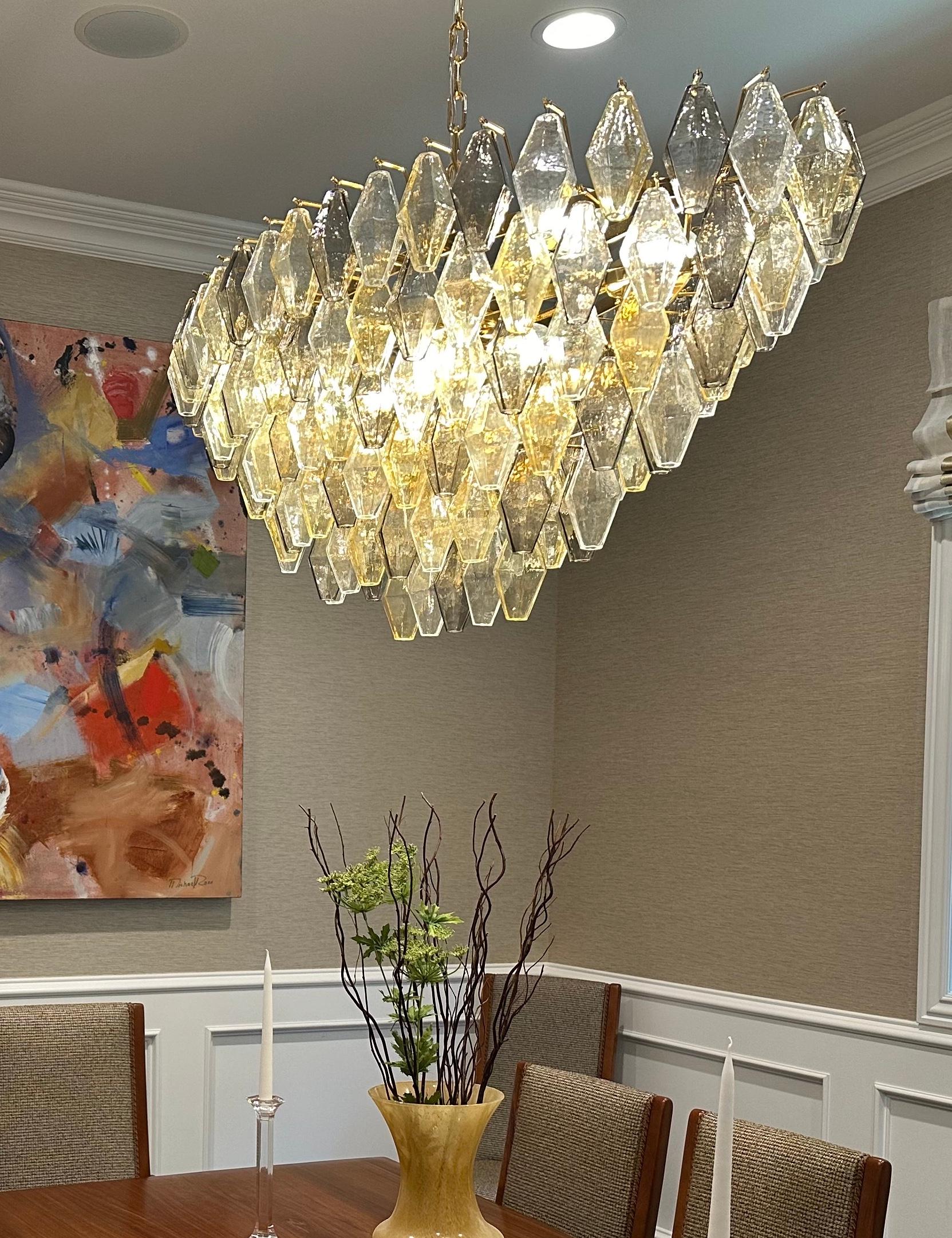 Questo lampadario è composto da decine di pezzi soffiati a mano di colore grigio e ambra,  e 
