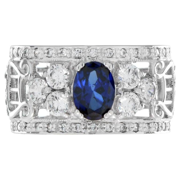 This beautiful ring is centered with an oval cut natural sapphire and accented with round brilliant cut diamonds. The intricate design makes this ring a perfect choice as a wedding anniversary ring for men or women who are looking for an eye