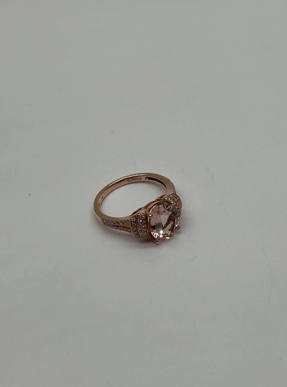 Un anello raffinato ed elegante con una gemma centrale dal taglio ovale di una delicata tonalità blush. L'anello è impreziosito da diamanti incastonati a pavé che affiancano la pietra centrale, aggiungendo un tocco di scintillio e raffinatezza. Oro