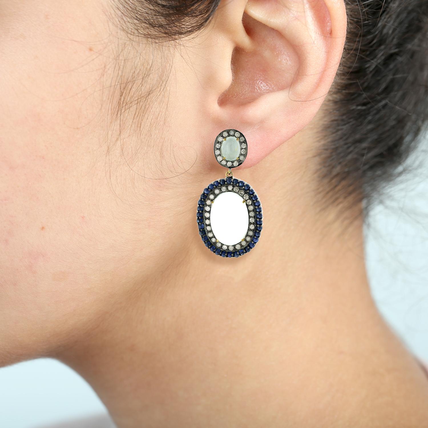 Make a fashion statement with these breathtaking Oval Shaped Agate Earrings. Surrounded by blue sapphires and diamonds, these earrings are sure to turn heads. The gems are set in a pave setting, adding an extra touch of glamour to this already