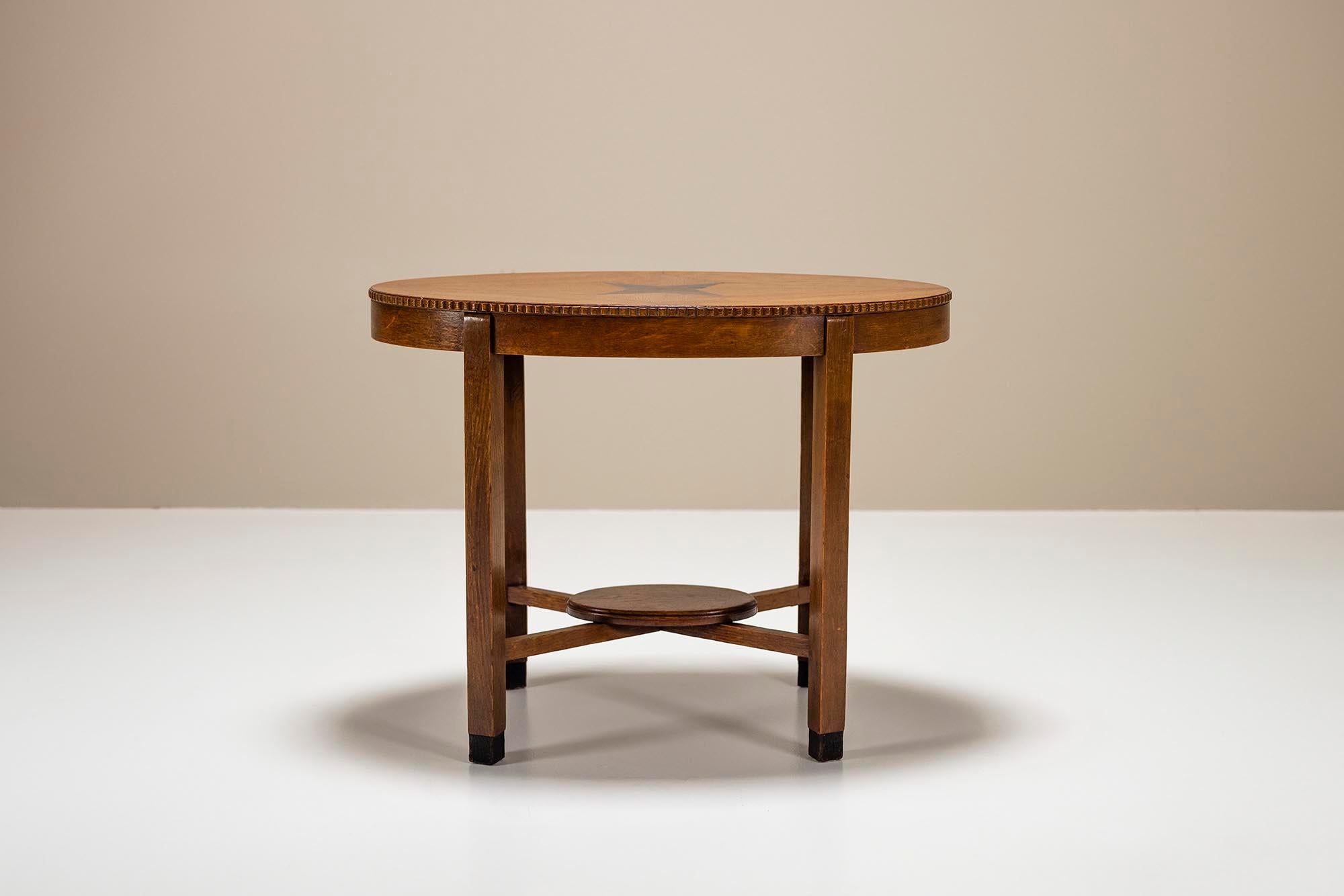 Crafted in the distinguished style of the Amsterdam School, this side table exudes elegance and sophistication. Carved from solid oak, its oval-shaped top is a testament to fine craftsmanship. At its center, a mesmerizing star-shaped ebony veneer