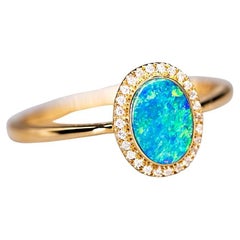 Bague en or jaune 14 carats avec opale doublet australienne de forme ovale et halo de diamants