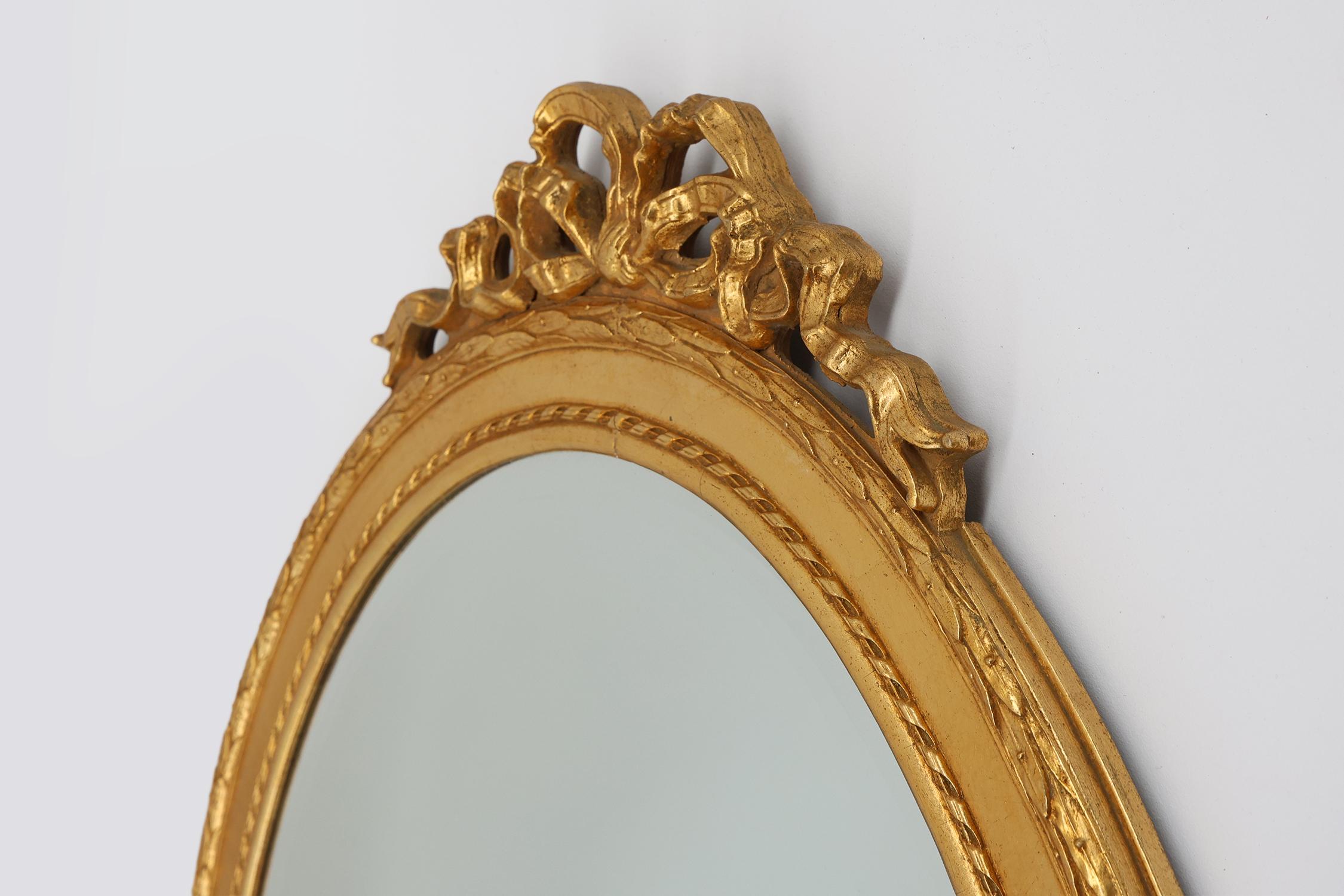 Mid-20th Century Oval shaped carved gilded Baroque mirror with beveled glass, Belgium For Sale
