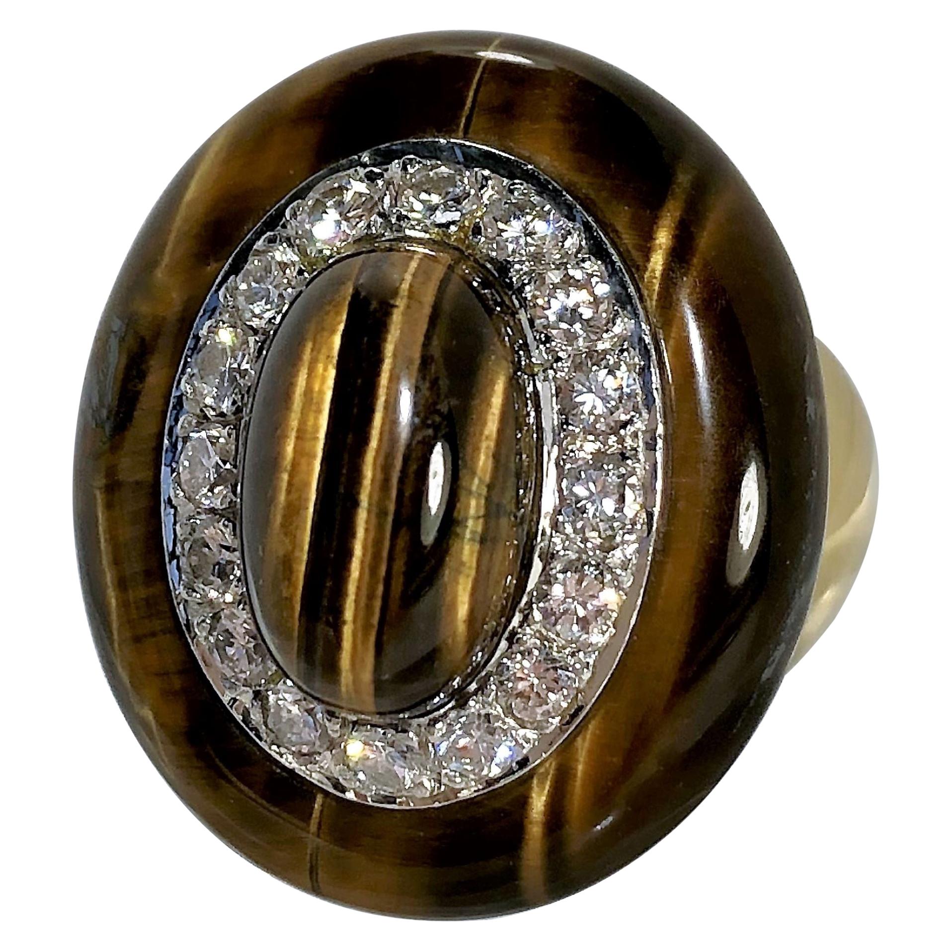 Crafted in 18K Yellow Gold, this striking 1970s oval shaped, Tiger's Eye and diamond ring
measures a substantial 1 inch high (25.3mm)  by 7/8 inch wide (22mm). The 16 round brilliant 
cut diamonds that surround the center Tiger's Eye Cabochon are