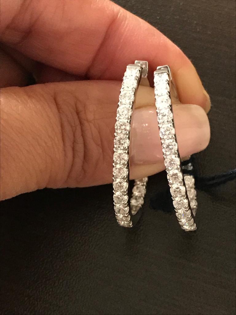 Oval shaped hoop earrings set in 18K white gold. The hoops are 1.25 inches in diameter. The total carat weight is 3.09 carats. The diamonds are set inside out. The color of the stones are F-G, the clarity is VS1-VS2.