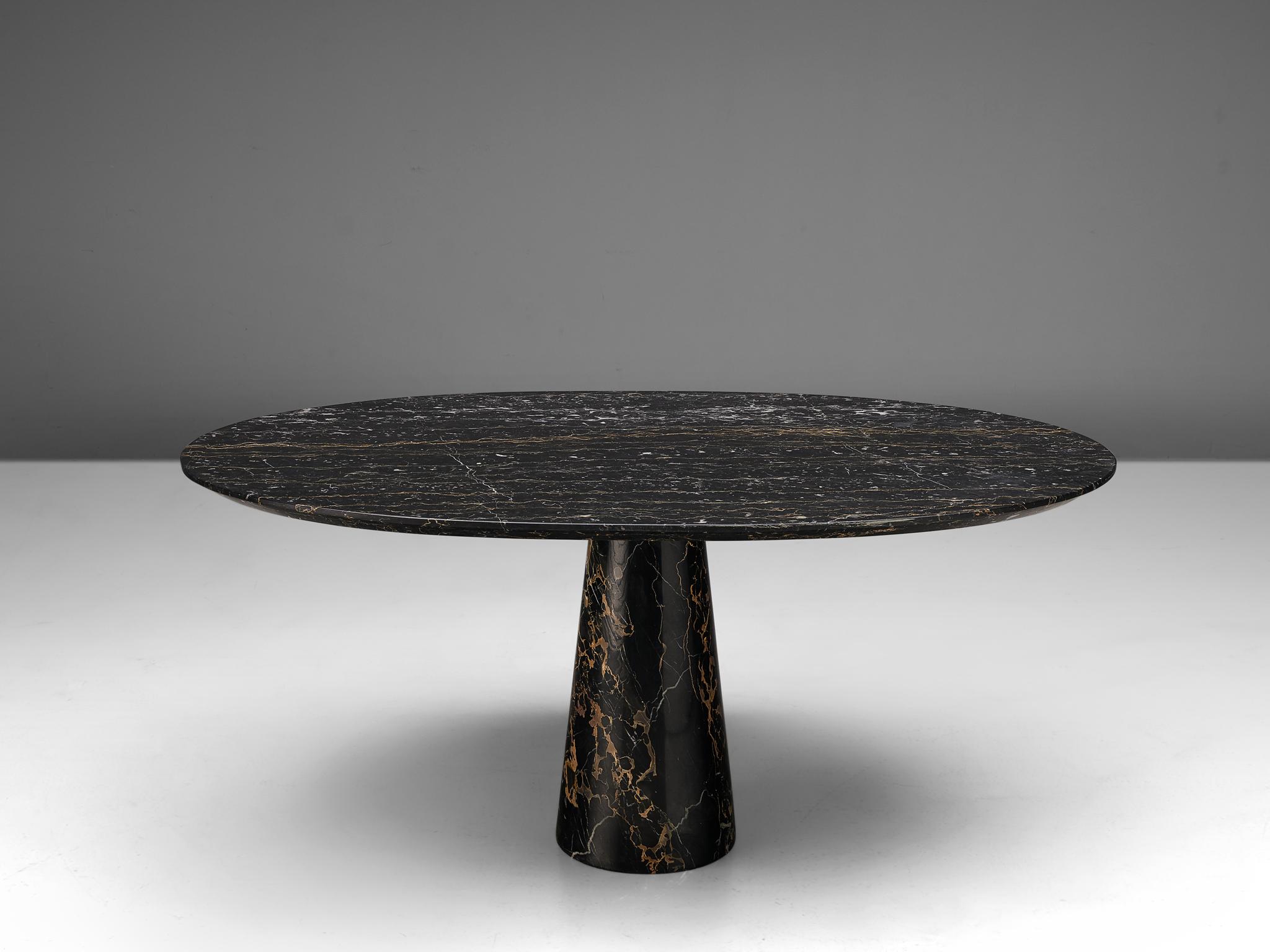 Oval shaped dining table, black marble, Europe, 1970s. 
 
This spectacular marble table consists out of an oval slab which rests onto a cone shaped foot. The dark marble has ochre golden and white veins that give this table a three dimensional