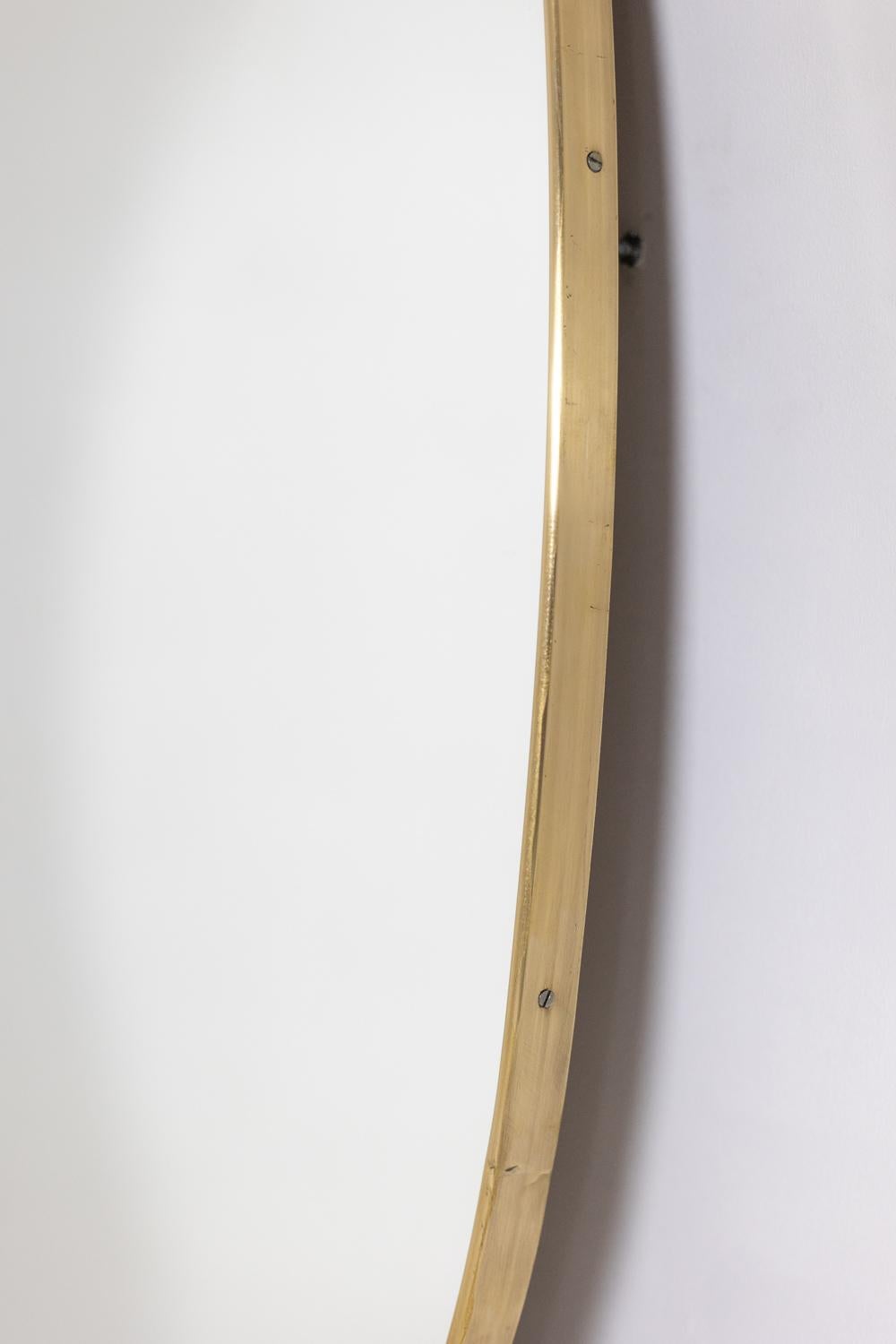 Gilt Oval-shaped mirror set with a gilded brass. 1970s.