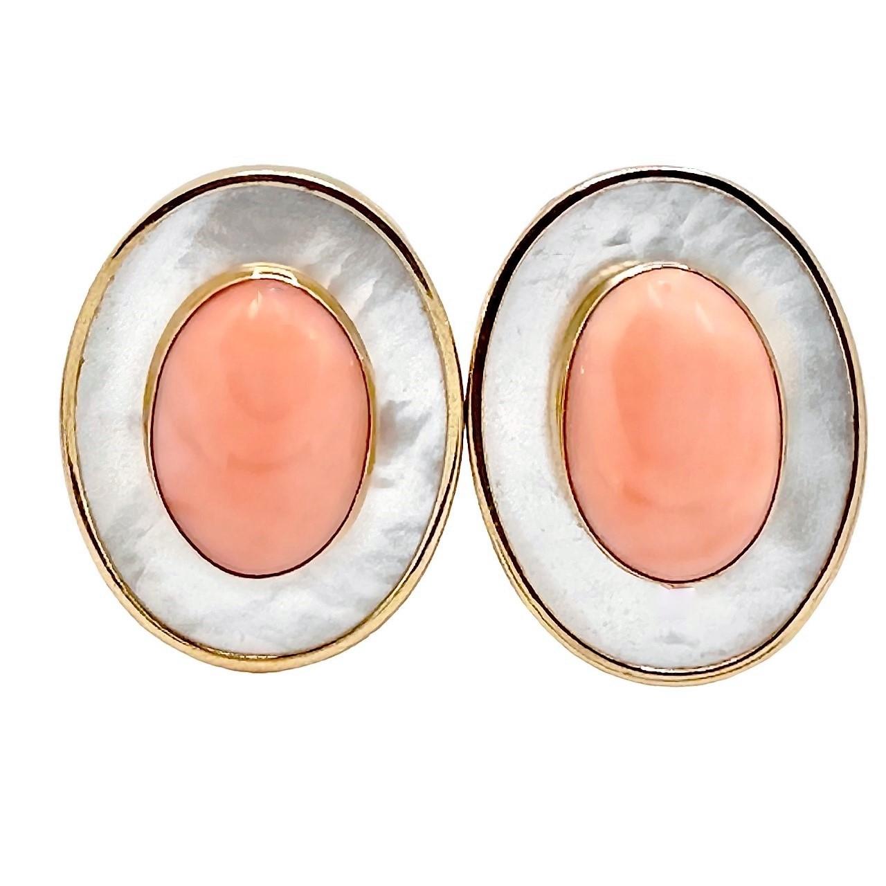 This pair of very aesthetic and soundly constructed 14K yellow gold clip on earrings are truly captivating, with two richly colored angel skin coral cabochons set in bezels on a background of vibrant mother of pearl. They are lightweight and