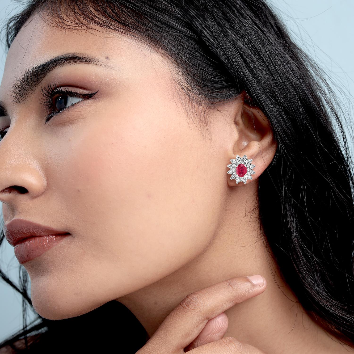 Ces minuscules clous d'oreilles ovales en rubis sont rehaussés de diamants étincelants, alliant couleur vibrante et élégance classique. Réalisé en or 18 carats, ce modèle présente un rubis du Mozambique de 0,72 carat associé à des diamants de 0,83