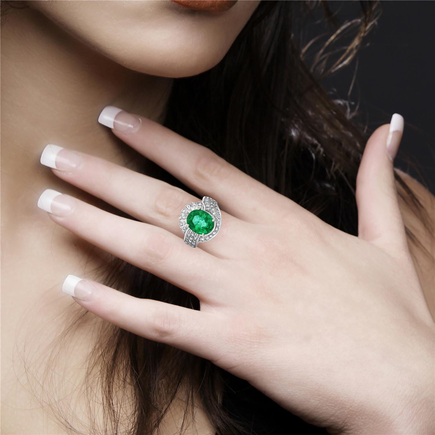 Make a statement with this stunning cocktail ring, featuring a vibrant oval-shaped Zambian emerald set in a luxurious 18k white gold band. The emerald's rich green hue is sure to turn heads, while the elegant setting enhances its beauty and