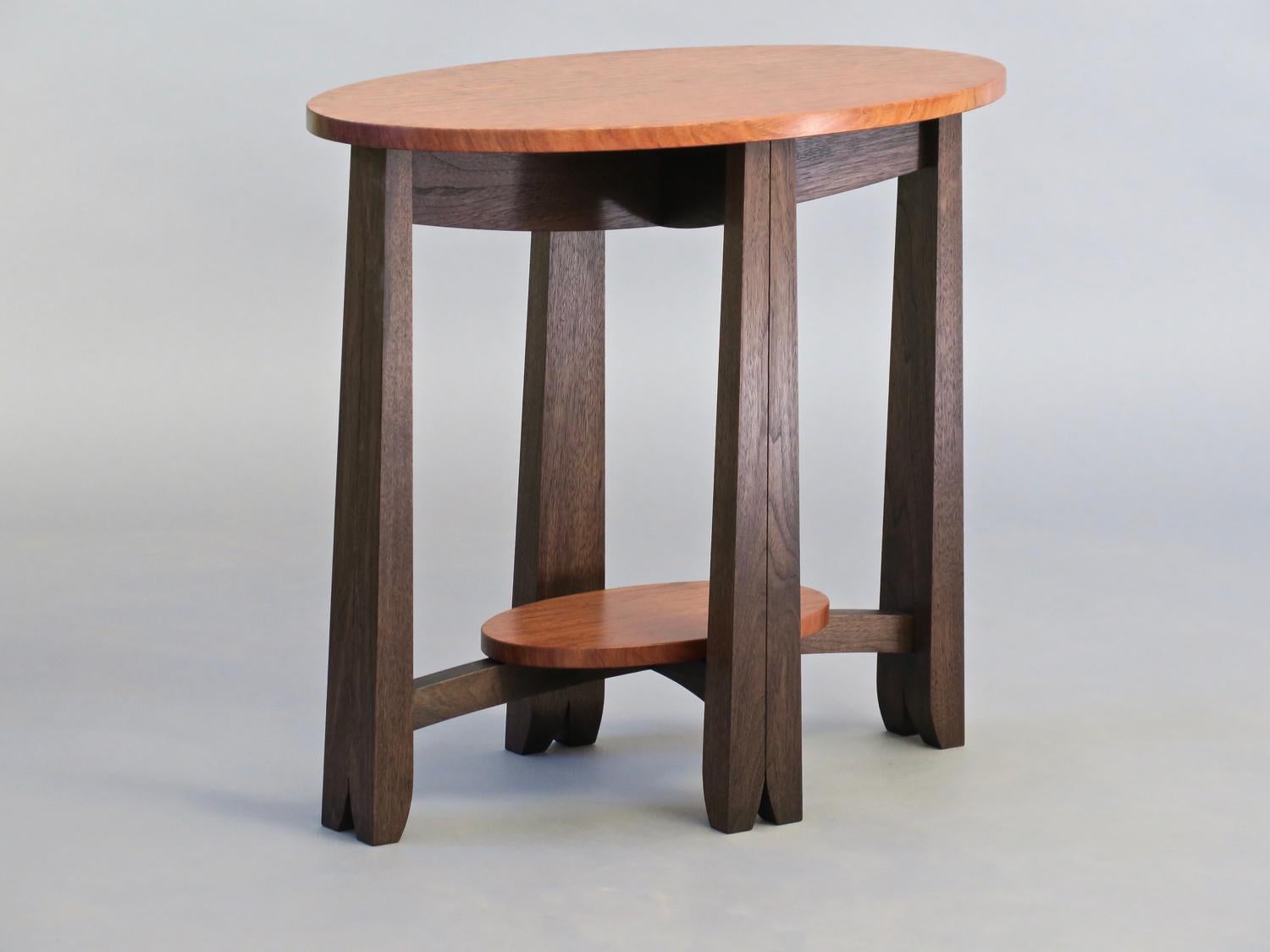 The oval Capistrano side table in blackened walnut and a contrasting figured bubinga top measures 28