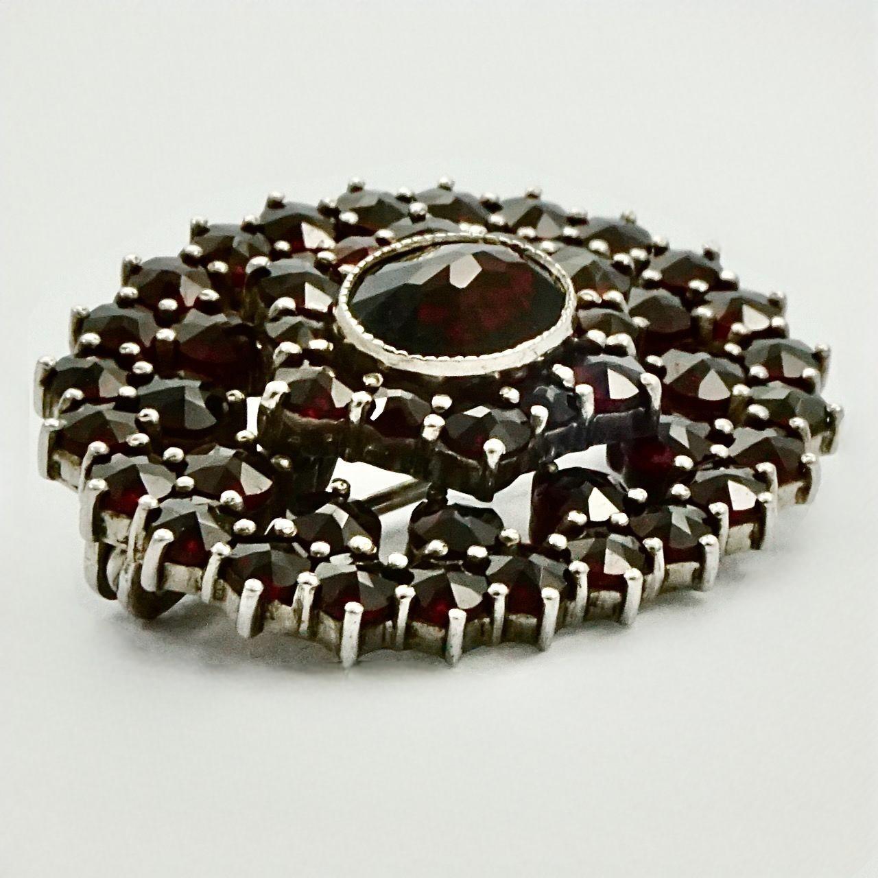 Round Cut Oval Silver and Garnet Brooch circa 1930s For Sale
