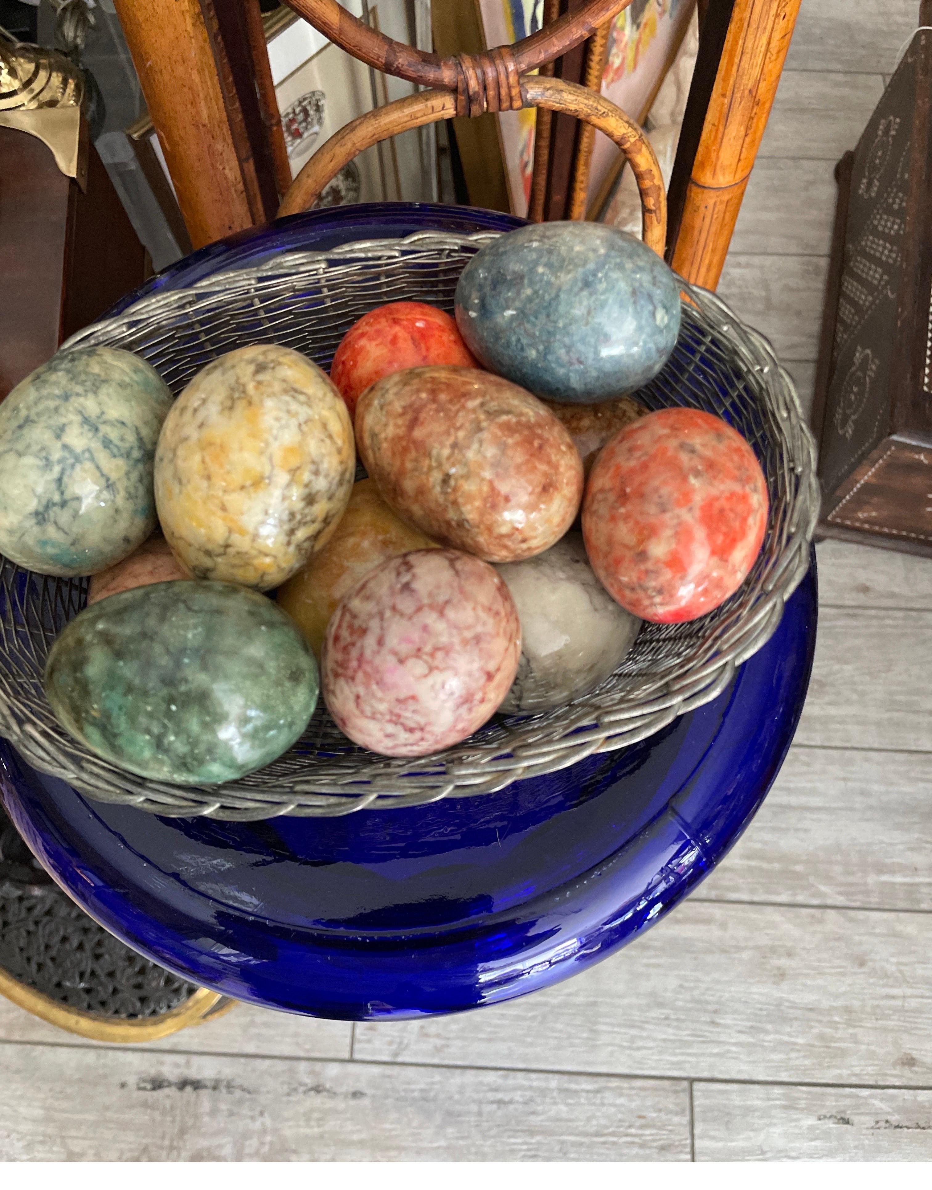 Oval woven silver plate basket filled with an assortment of multicolored Italian easter eggs.