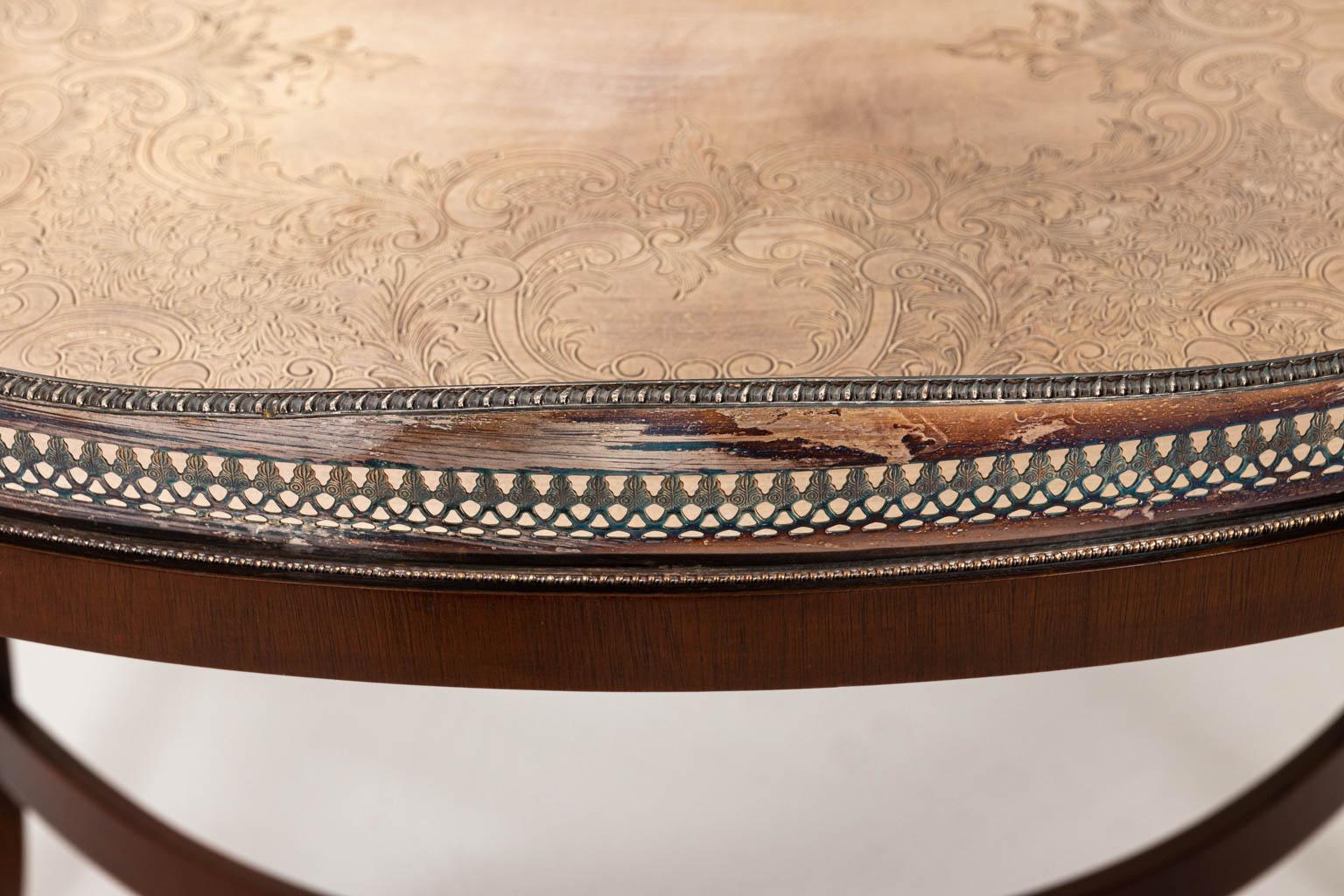 Oval shaped silver plate tray table on mahogany base. Please note of wear consistent with age including oxidation and patina on the silver play tray along with minor finish loss and chips to the mahogany base.
 