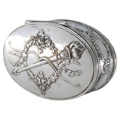 Oval silver snuff box with raised torch lid and gold interior