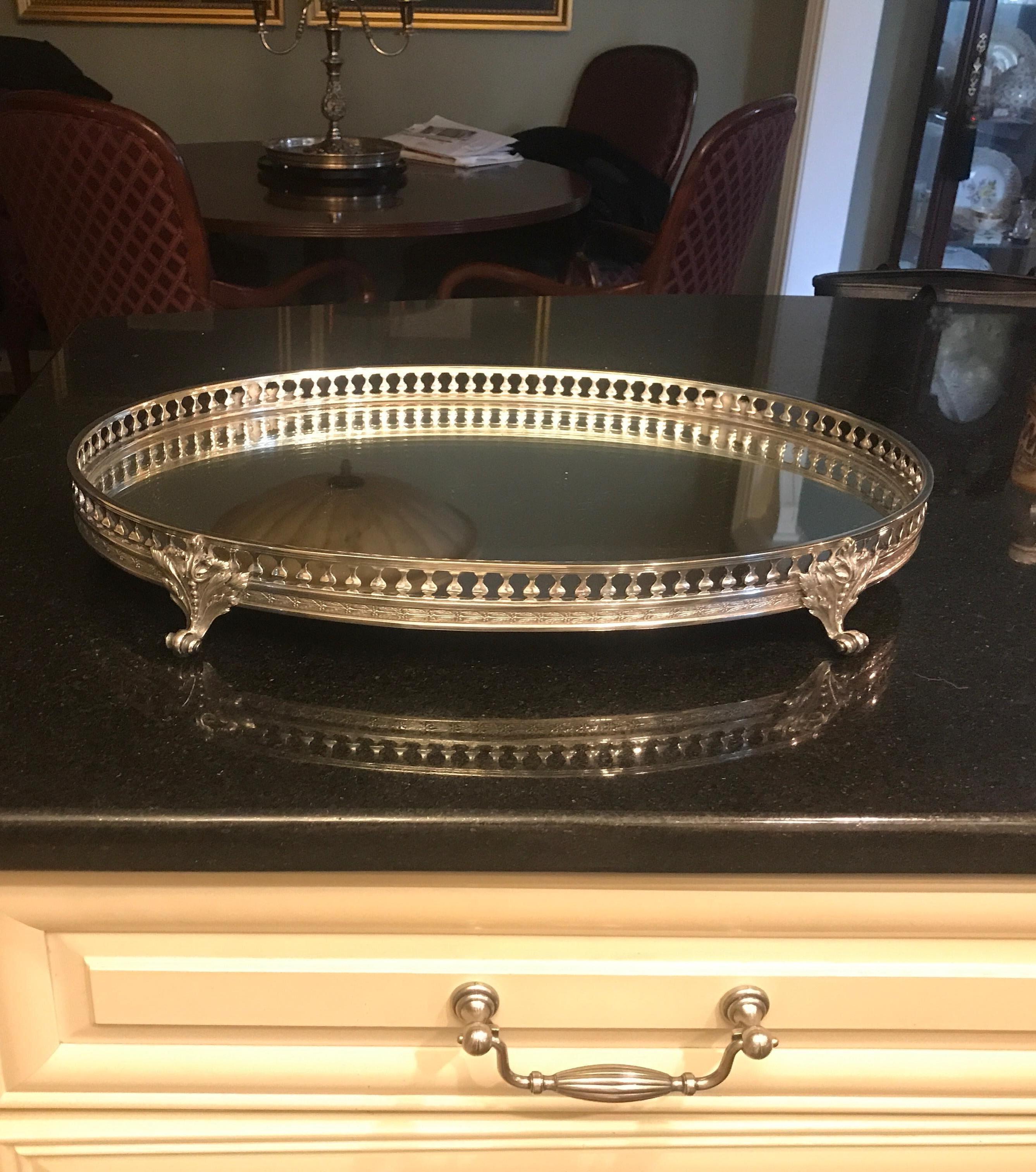 A cast and silver plated bronze framed oval plateau with mirrored surface. An elegant way to feature a prized pieces of silver or collection of smaller items, The original mirrored surface with a few light scratches, the silvering on the mirror and