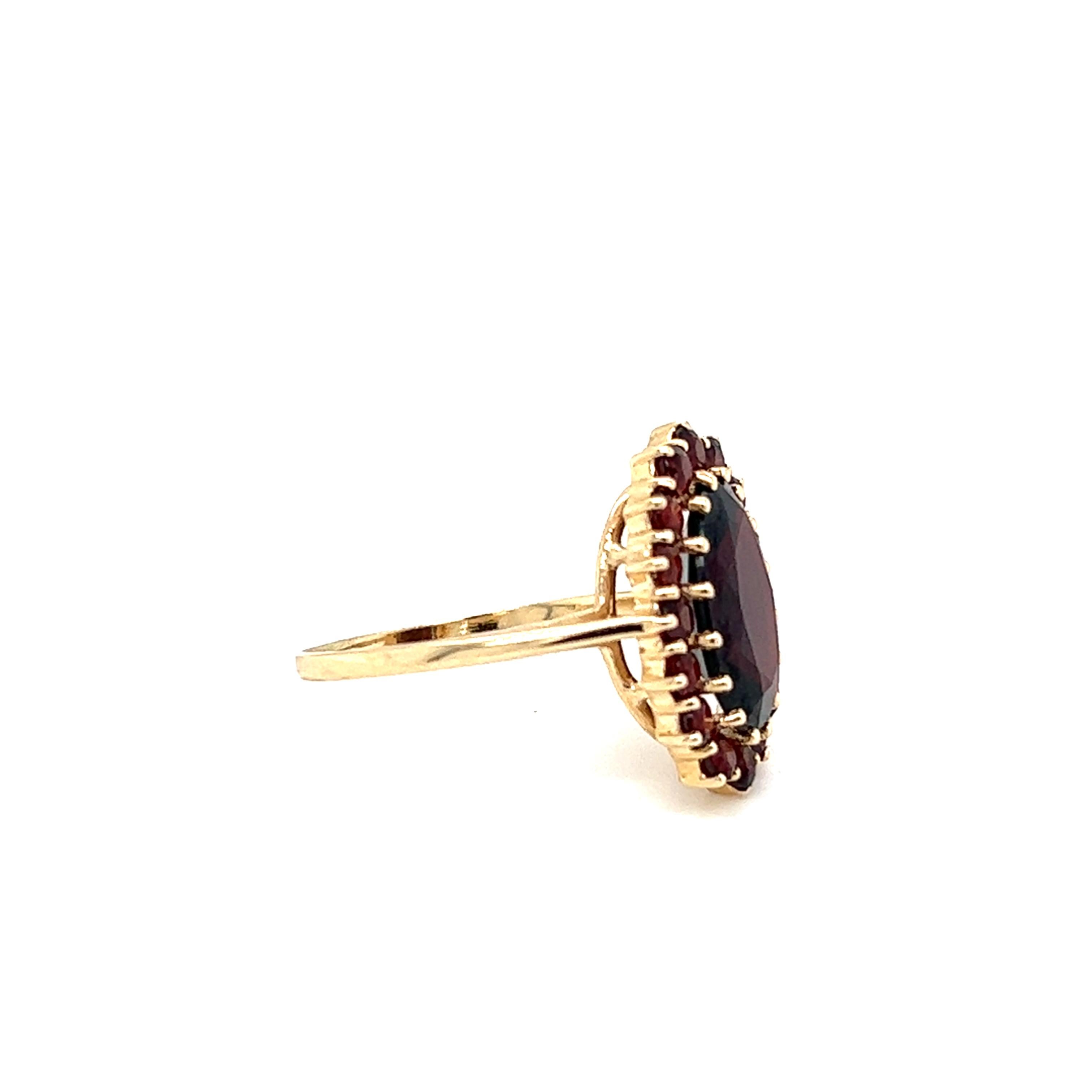One (1) 10k yellow gold ring featuring one (1) oval spessartite garnet measuring 13.00mmX 8.5mm weighing approximately 5.0 carats and sixteen (16) 2.5mm round faceted spessartite garnets weighing approximately 1.44 carats total weight.  The stones