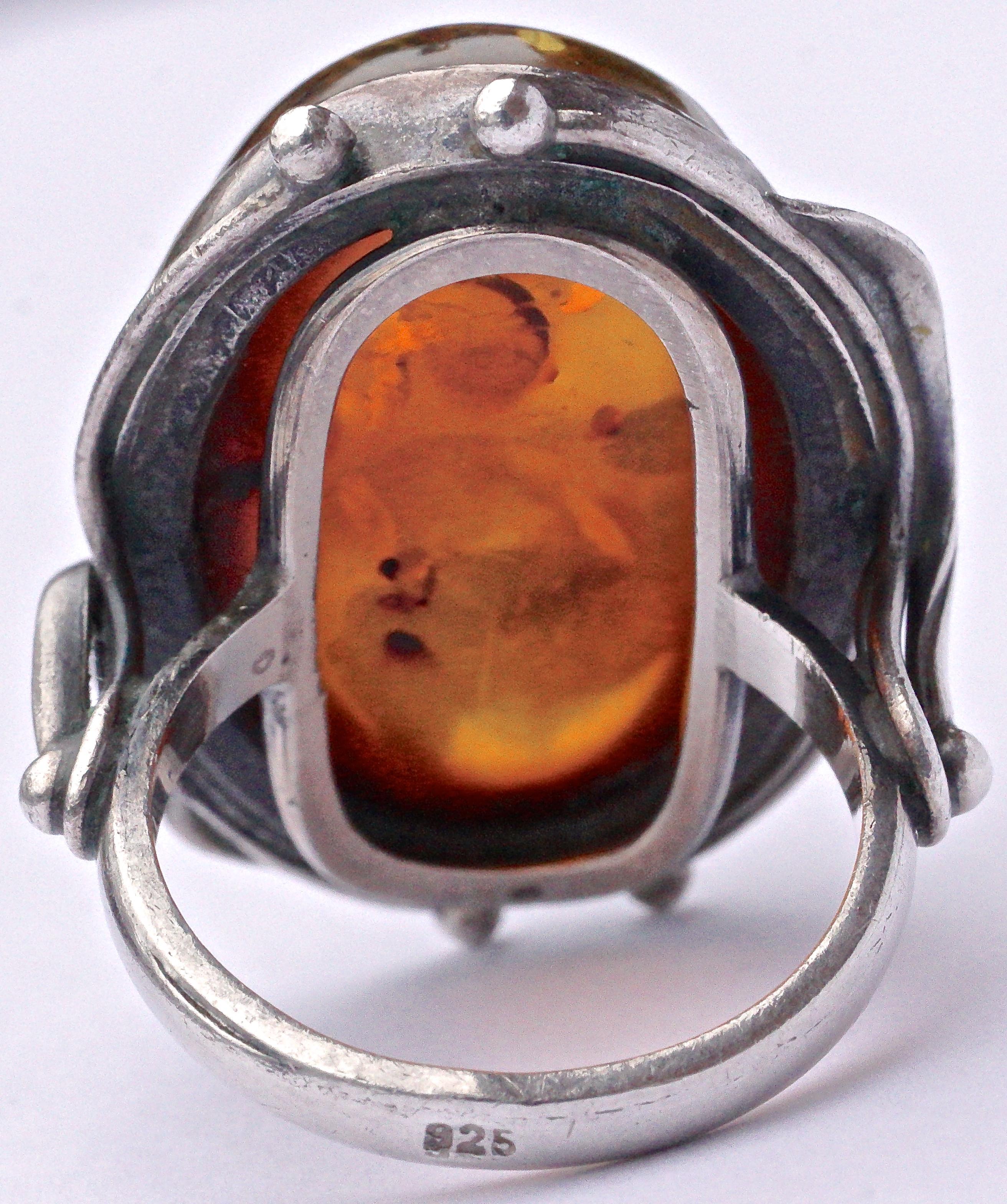 Large silver ring featuring a beautiful oval amber stone with many wonderful inclusions. Ring size UK N / US 6 1/2, inside diameter 1.7cm / .67 inch, and the amber stone is 2.6cm / 1.02 inch by 1.7cm / .67 inch. The amber is set in sterling silver