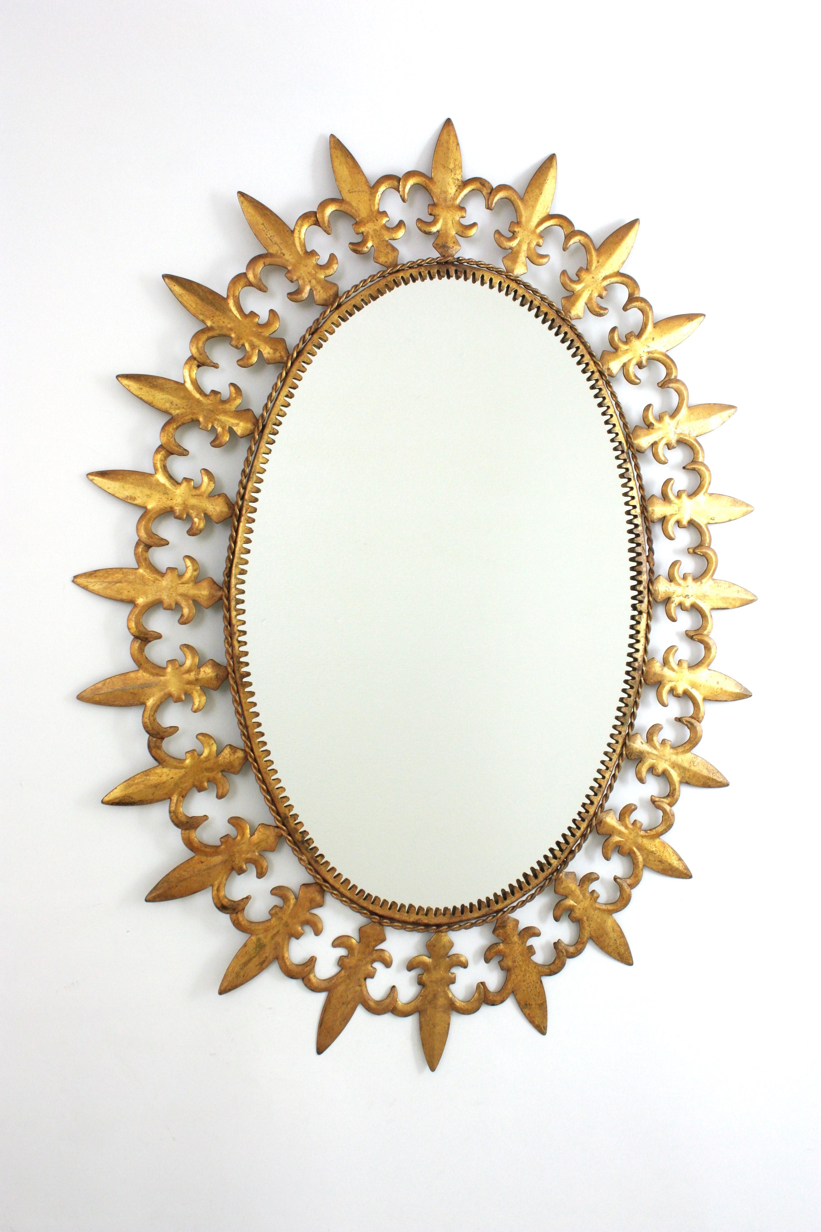 Miroir mural ovale en métal doré à effet de soleil
Miroir mural ovale en fer, de style moderne du milieu du siècle, avec motifs de fleurs de lis et finition à la feuille d'or, Espagne, années 1950.
Ce miroir en forme de soleil attire l'attention et