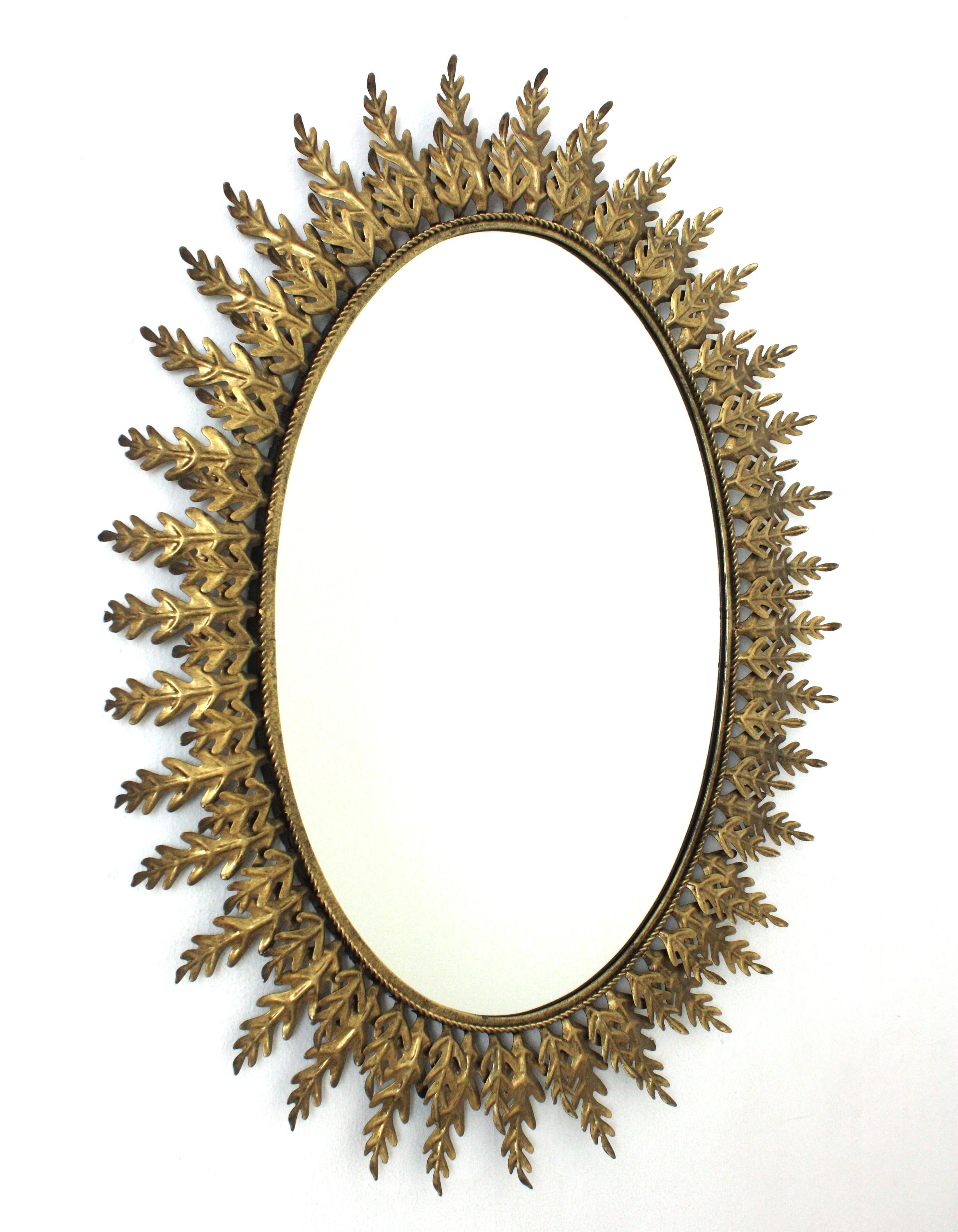 Ovaler Sunburst-Spiegel mit Blattrahmen, vergoldetes Metall, 1960er Jahre (Hollywood Regency) im Angebot
