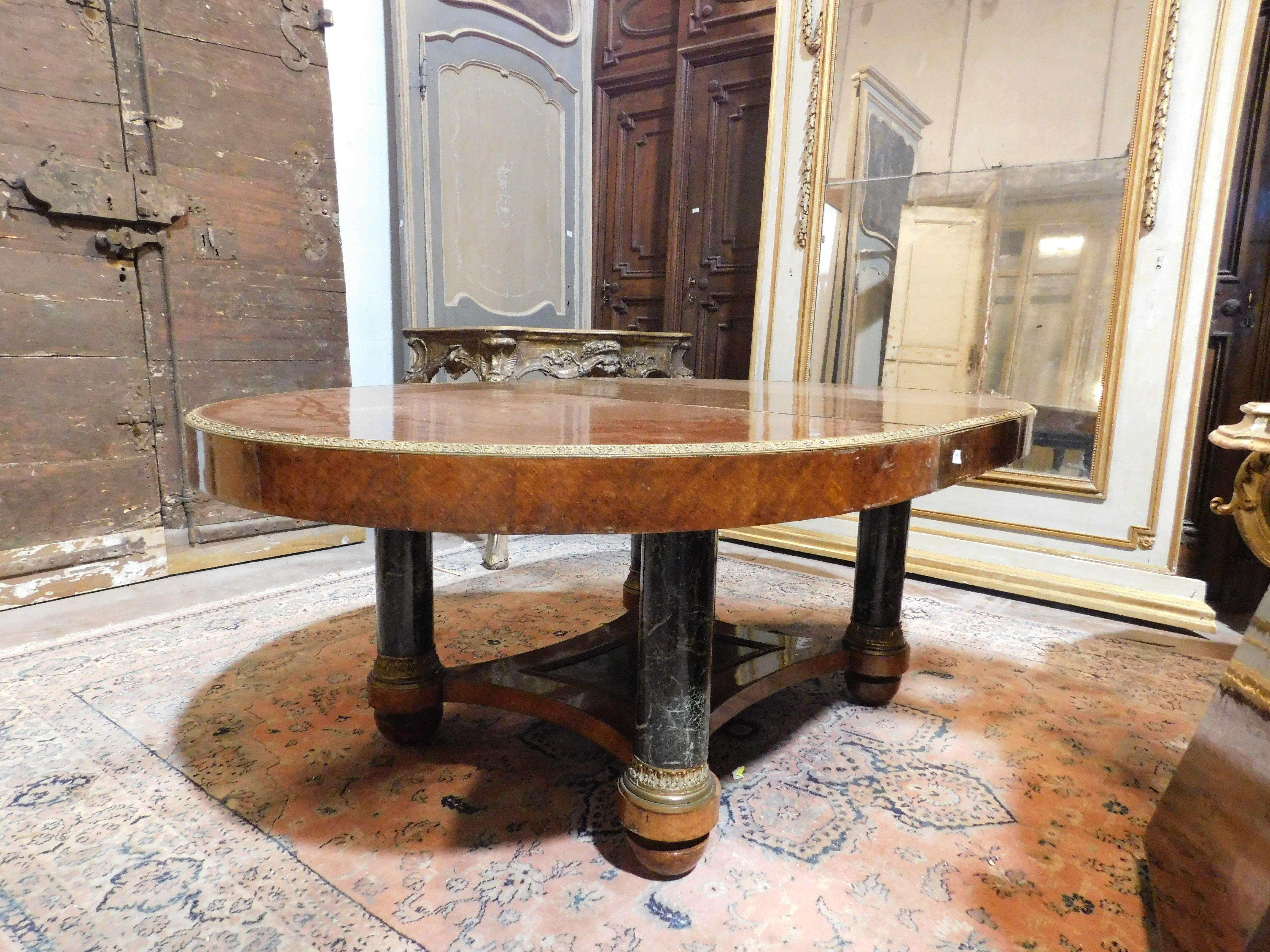 Antique vintage dining room table, oval shape in walnut wood, inlaid briar, complete with column legs in imitation Verde Alpi marble and golden bronze docris, built in Italy in the 20th century, has 2 extensions to add to expand the size. closed