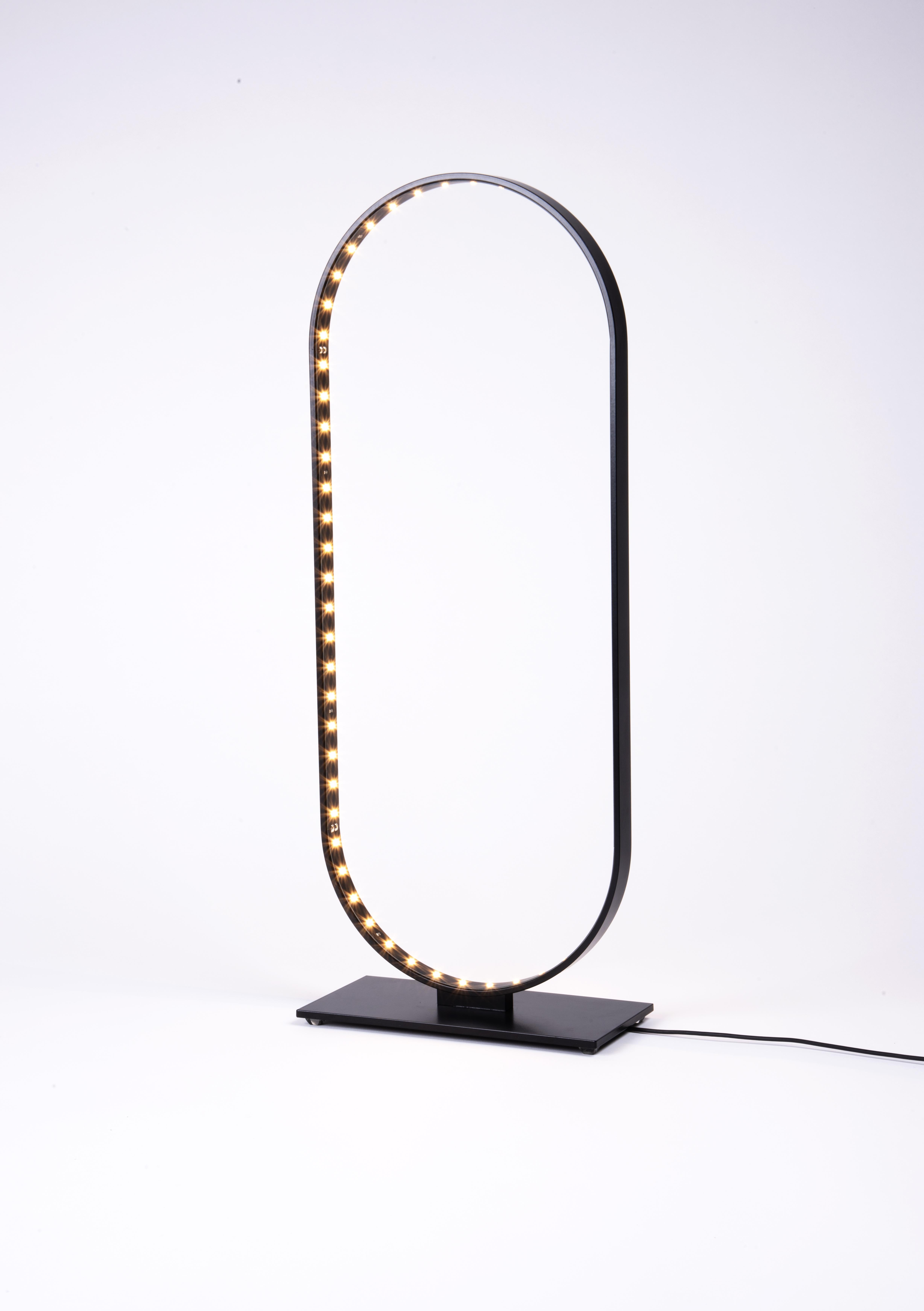 Oval Table Lamp by Le Deun Luminaires
Dimensions: W 21 x D 8 x H 55 cm. 
Materials: Epoxy painted steel.

They are a French company established in 1997, specializing in designing and manufacturing low-energy consumption lighting. They have been