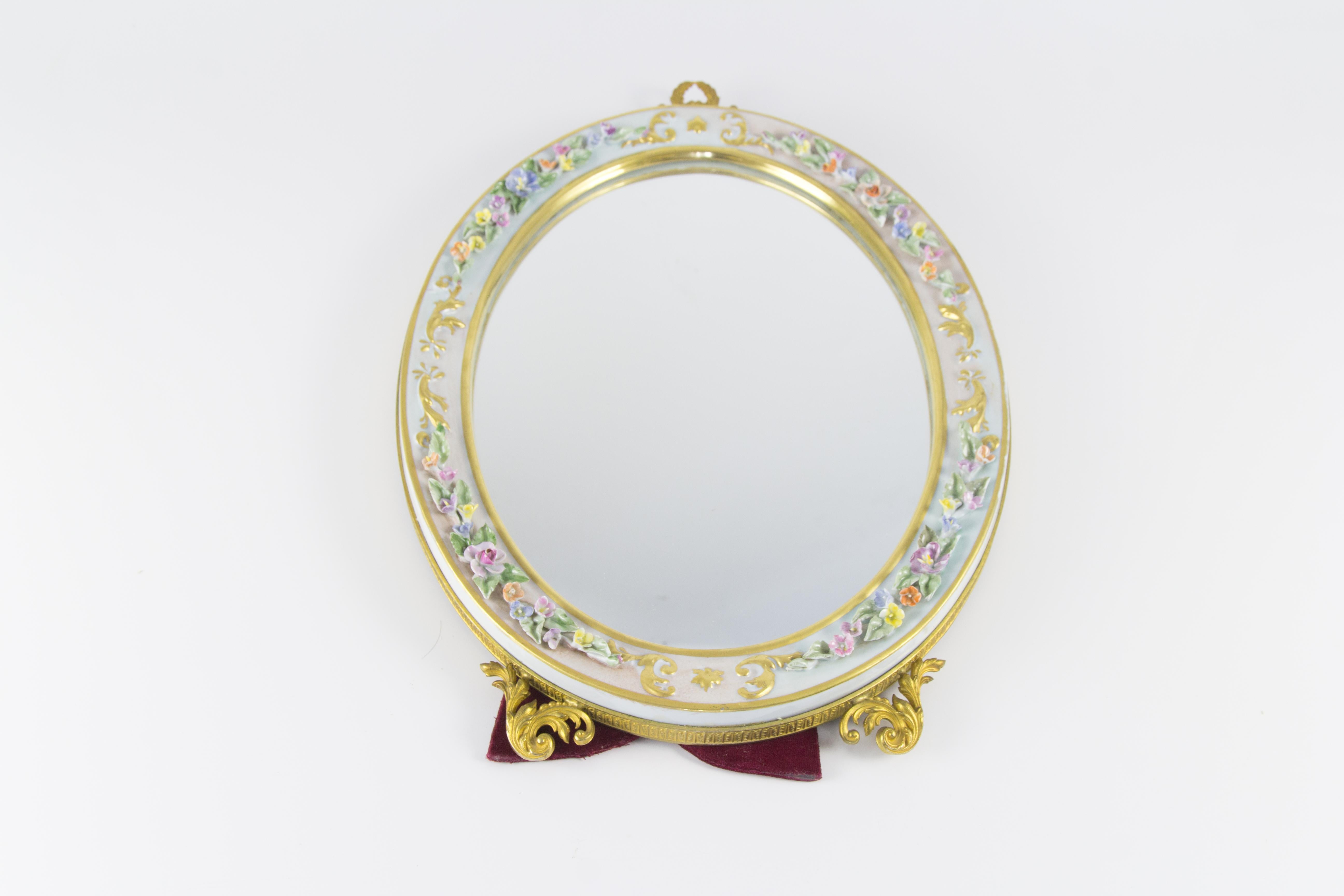 Vintage oval table mirror with porcelain frame and golden-colored metal decors. Italy, the 1950s.
The beautiful porcelain frame features detailed flowers and leaves in pastel tones.
Measures:
Height 41 cm / 16.14 in, width 28 cm / 11.02 in, depth 3